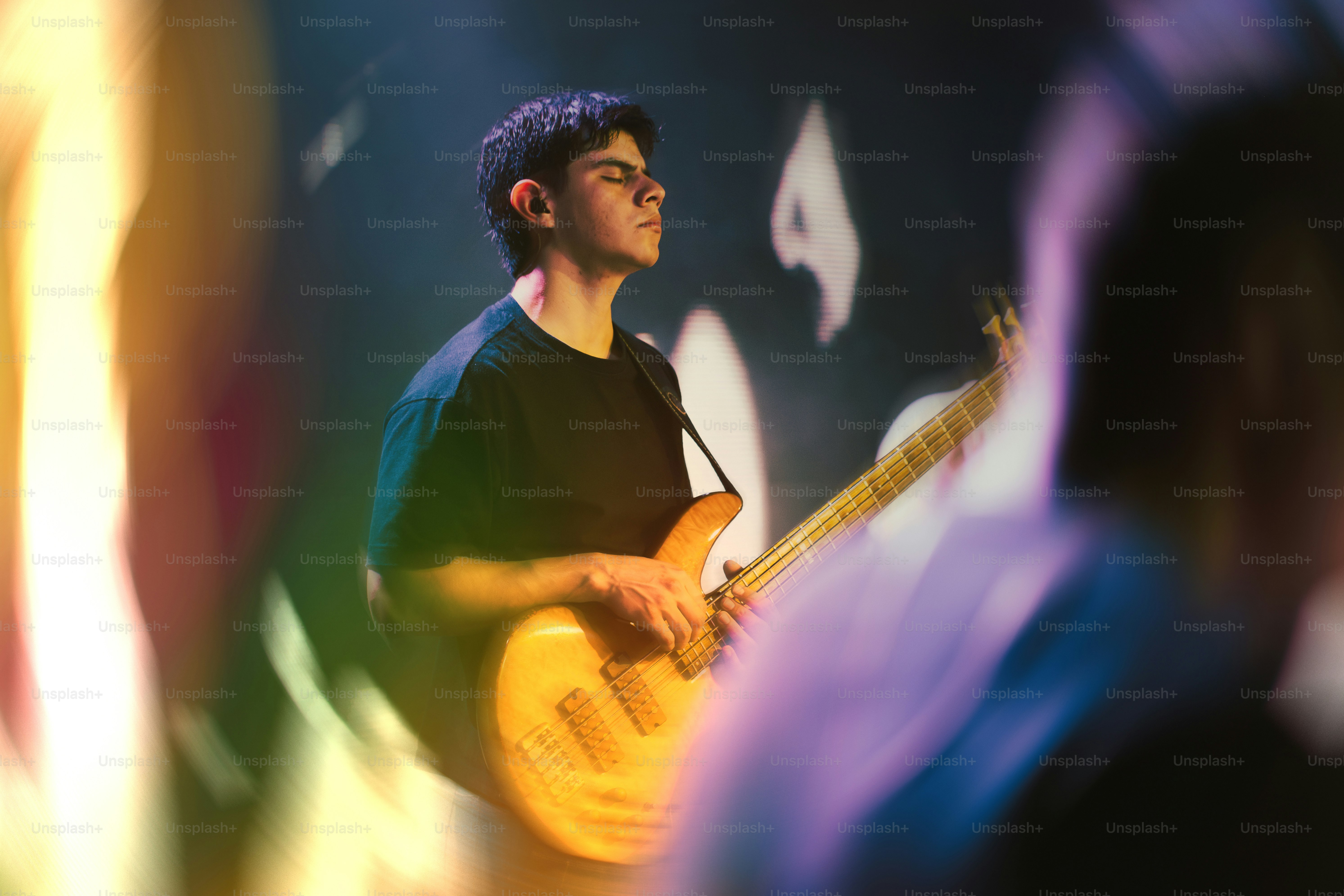 A musician plays bass guitar on a stage