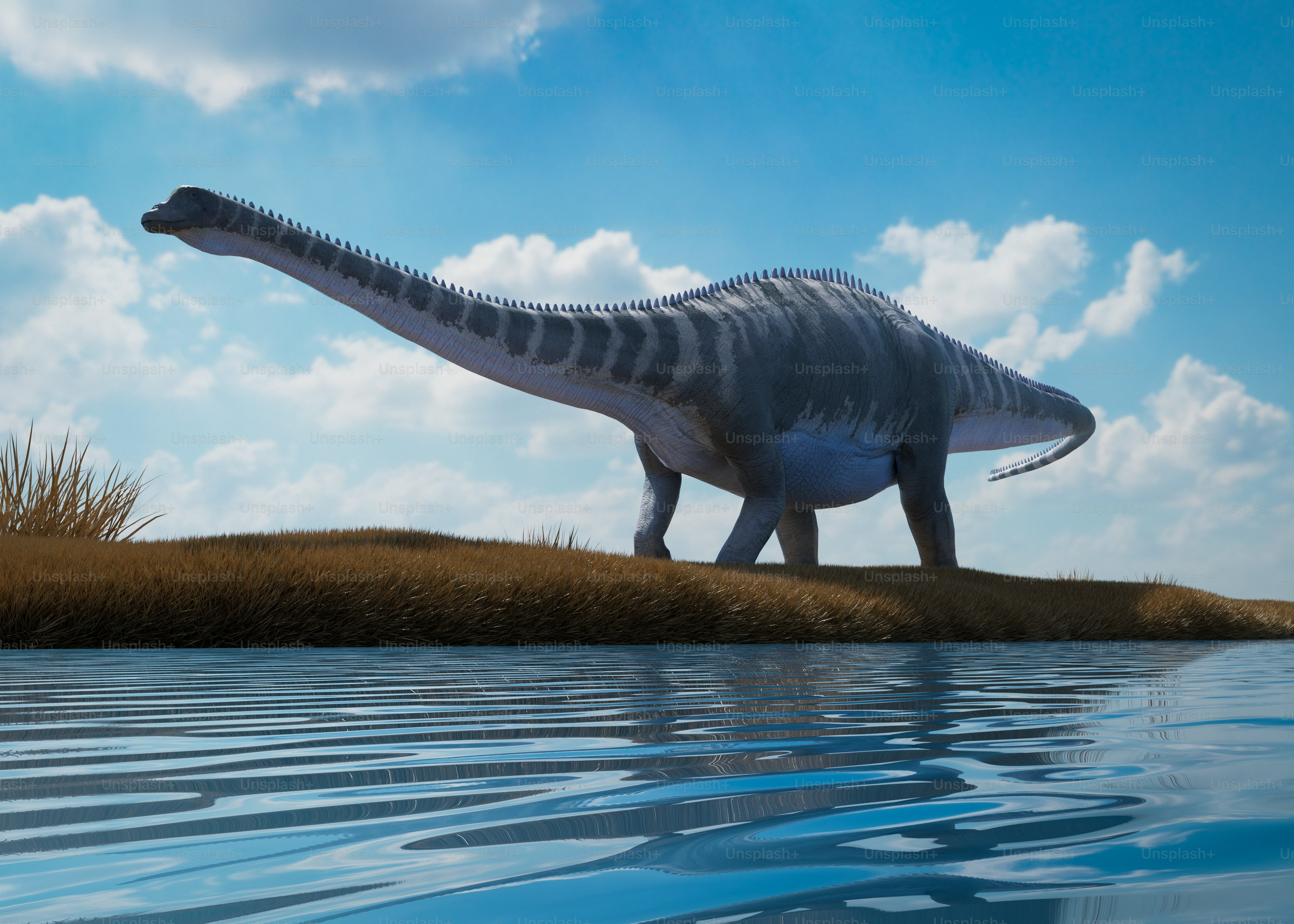 A sauropod dinosaur stands near water.