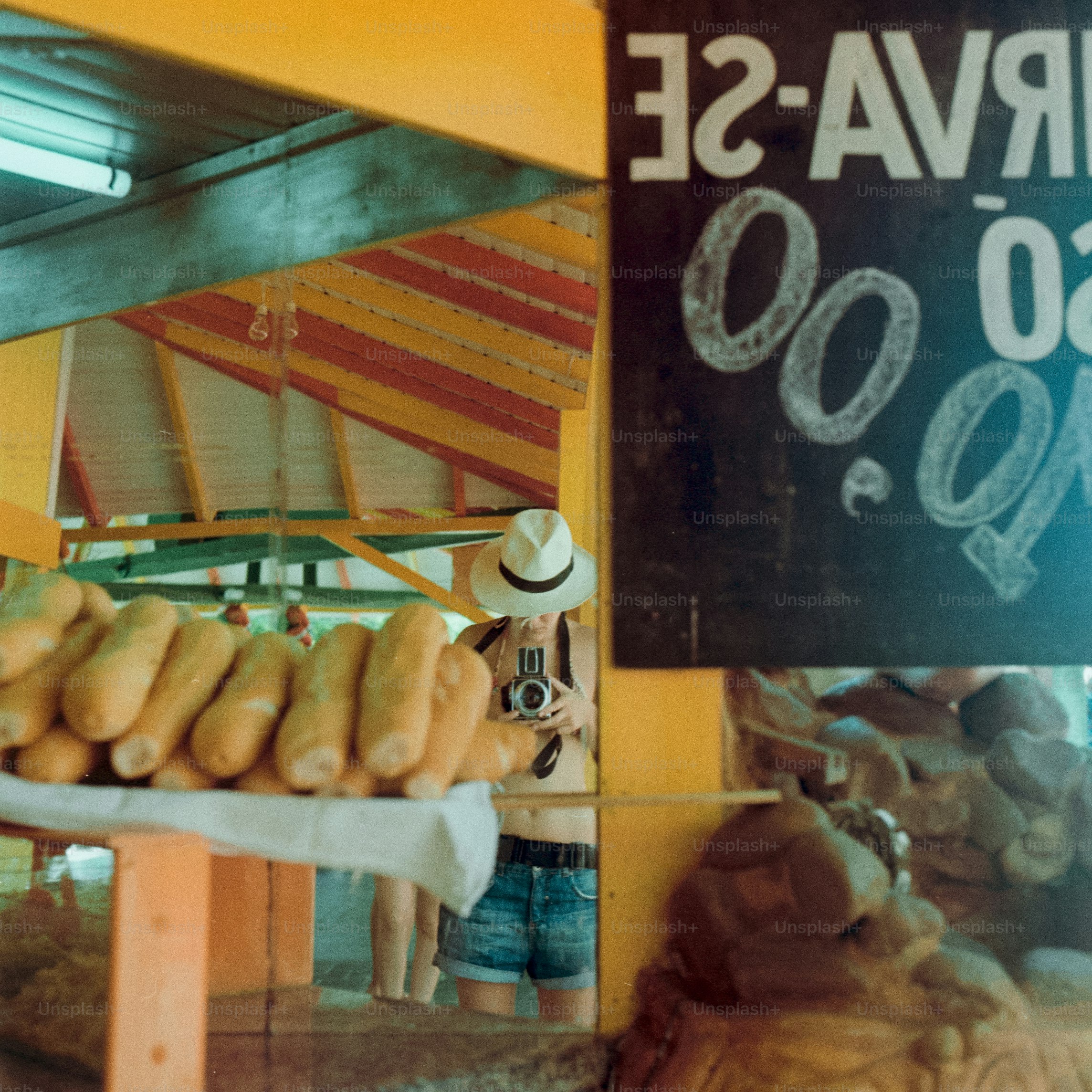 Eine Person macht ein Foto vor einem Obststand.