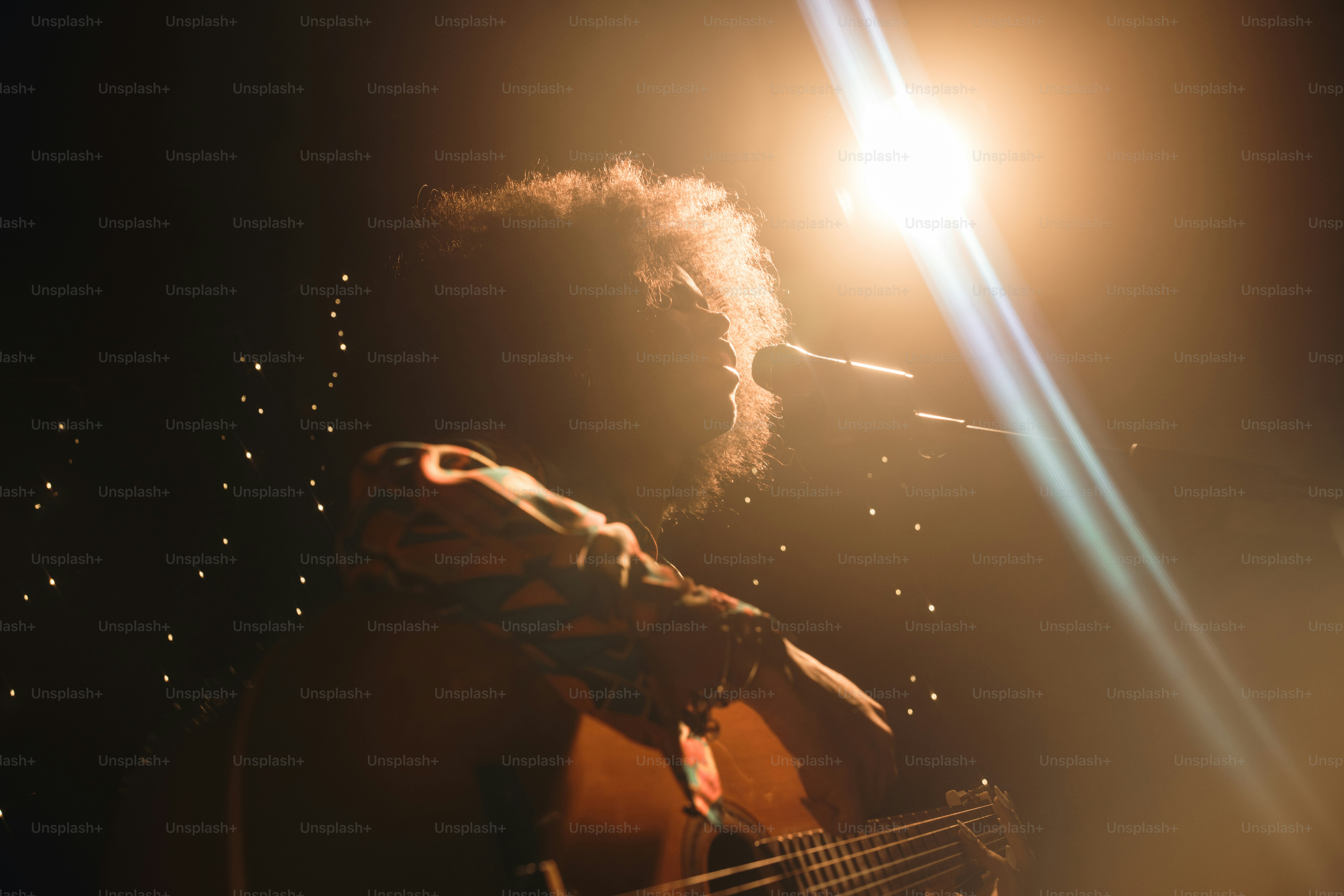 Un músico actúa bajo una brillante iluminación del escenario.