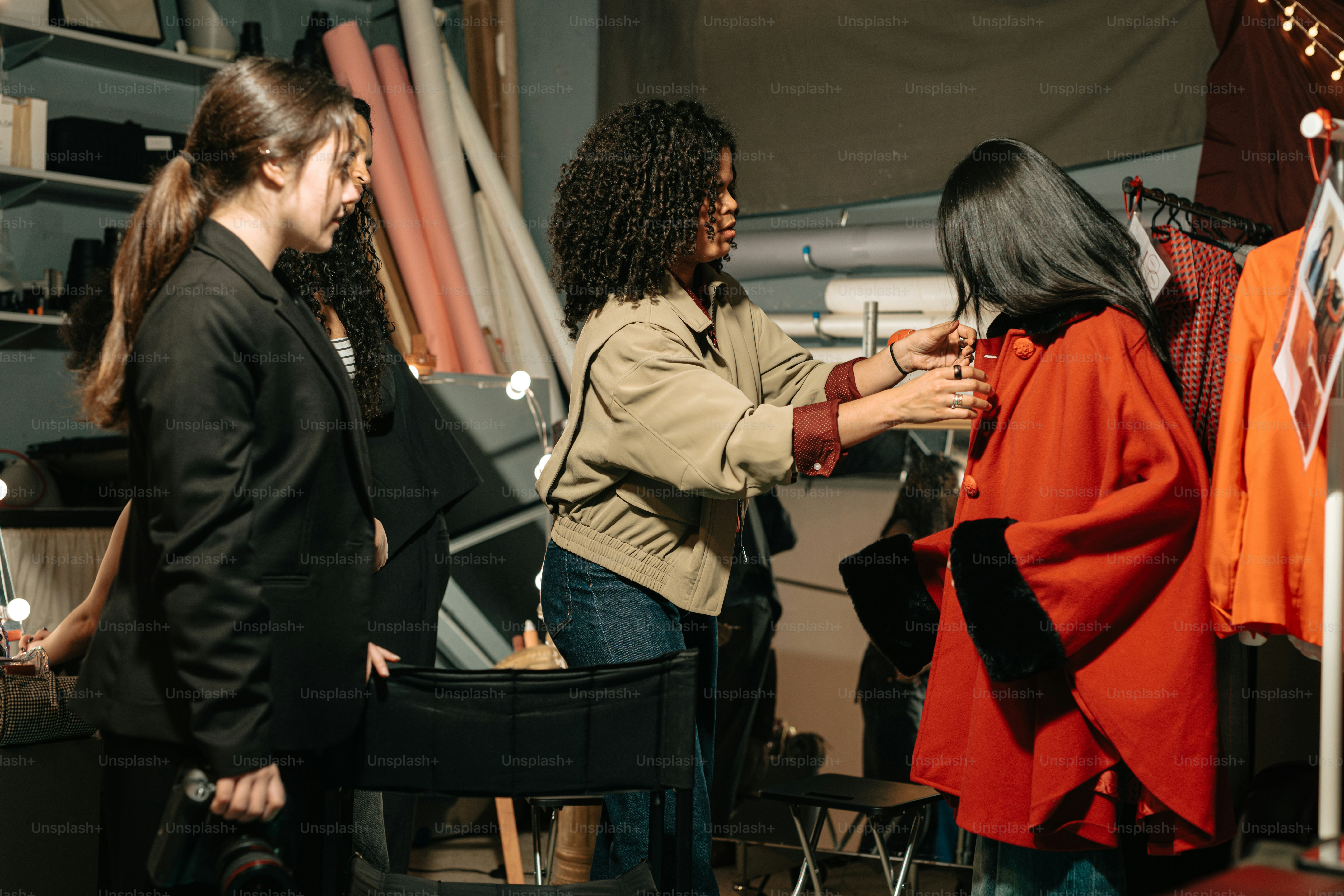 A stylist adjusts a model's outfit for a photoshoot.