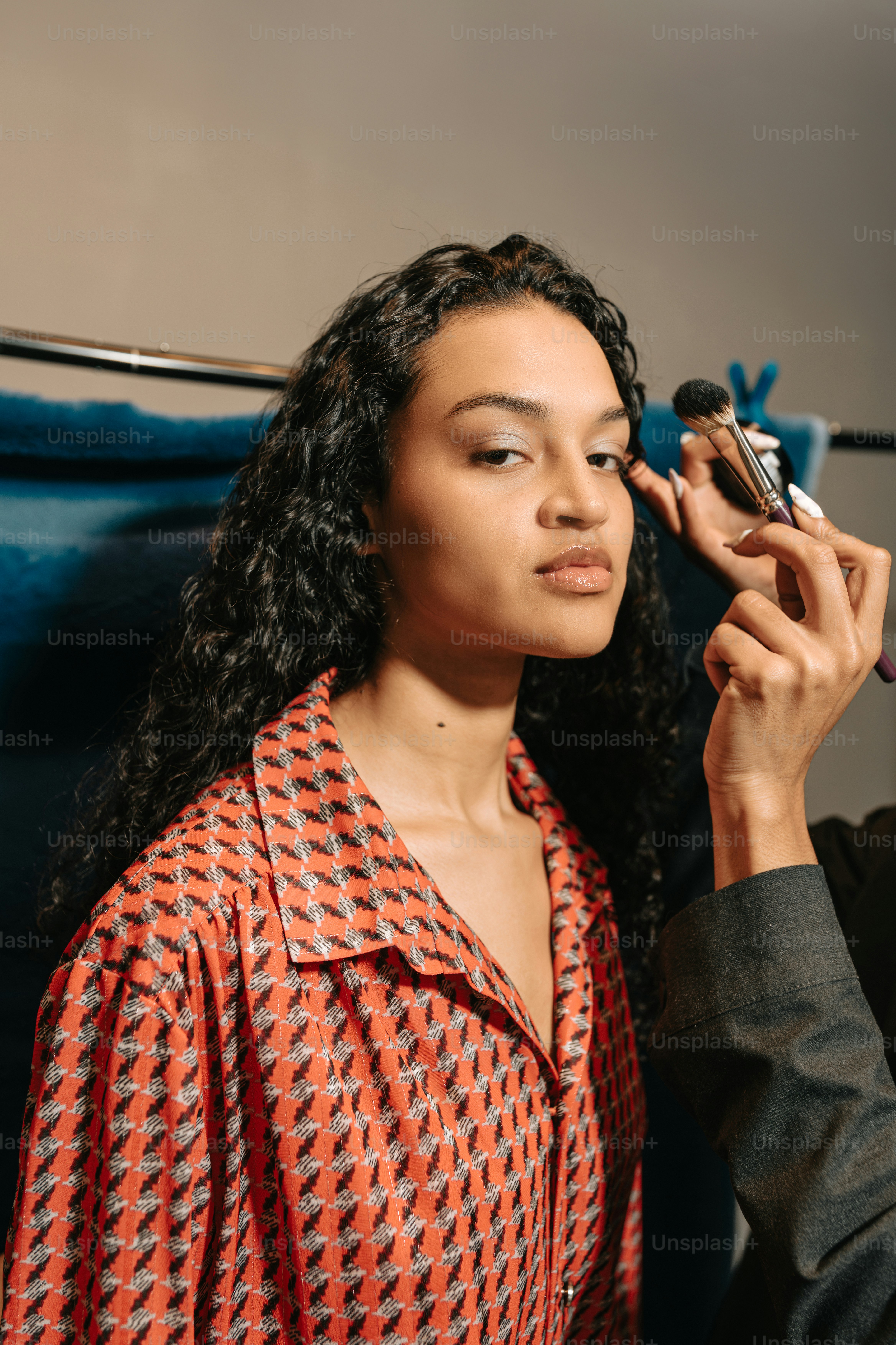 Makeup artist applying eye shadow to a model.
