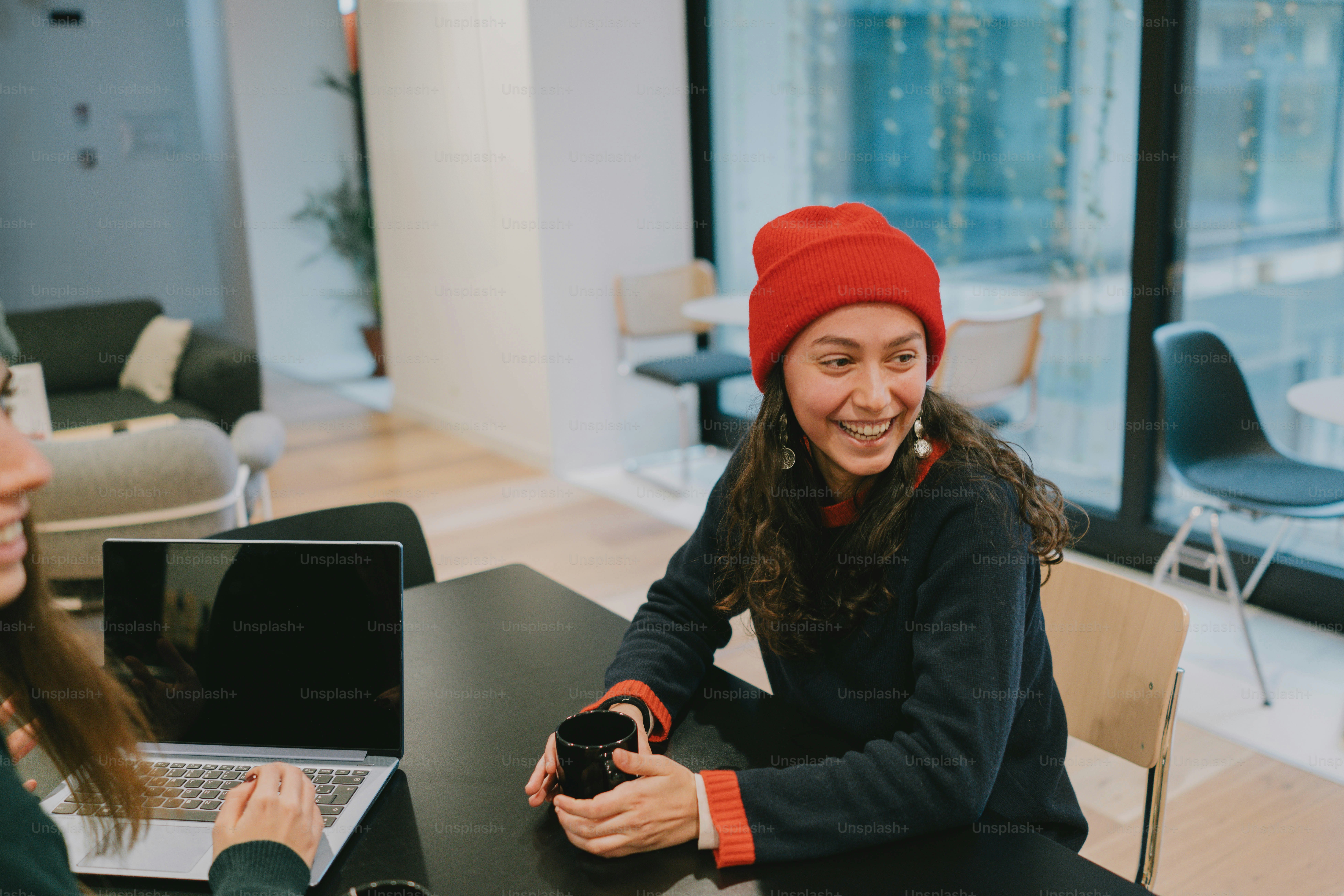 A woman smiles while holding a coffee mug.