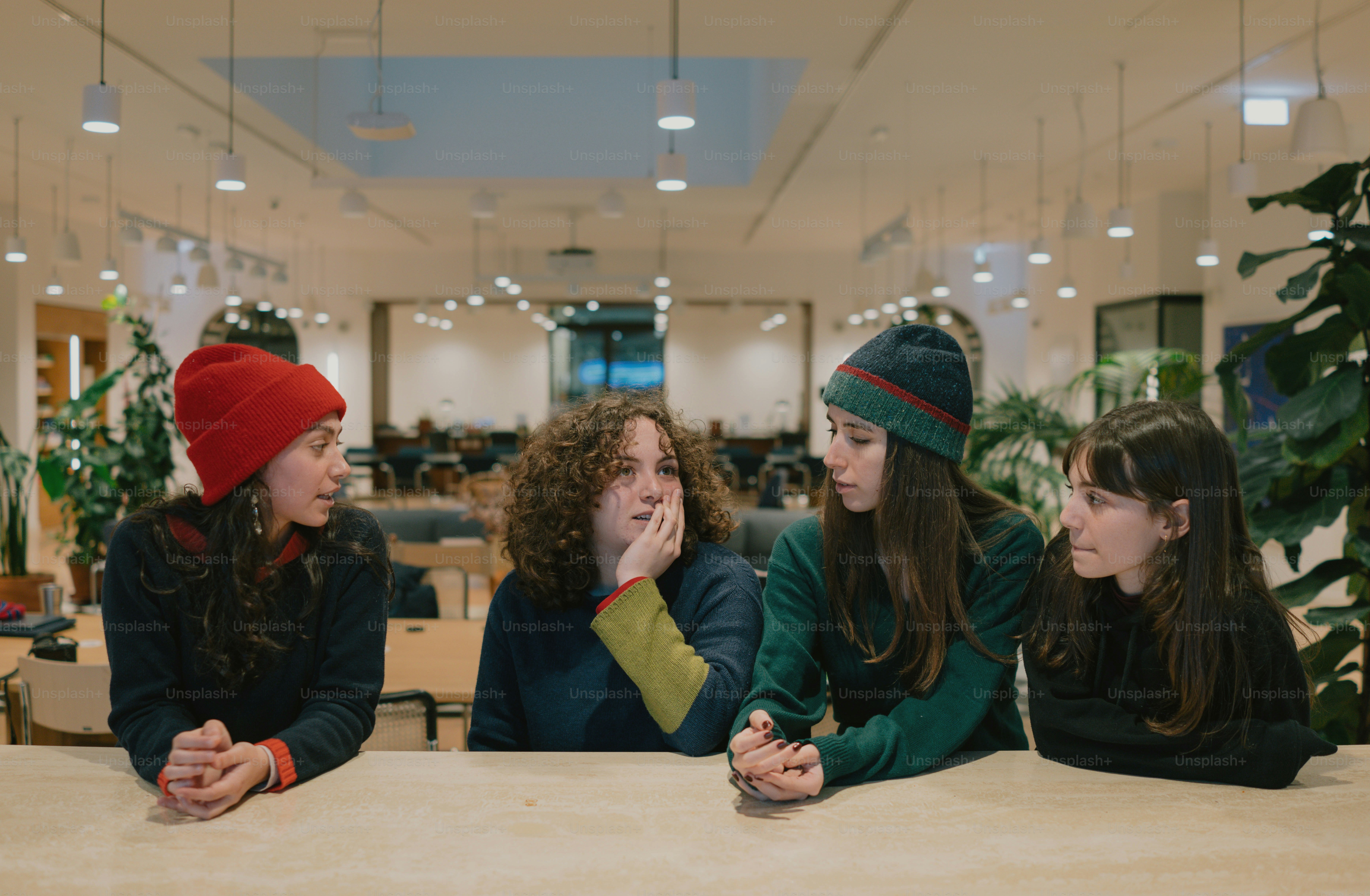 Four young women are sitting and chatting together.