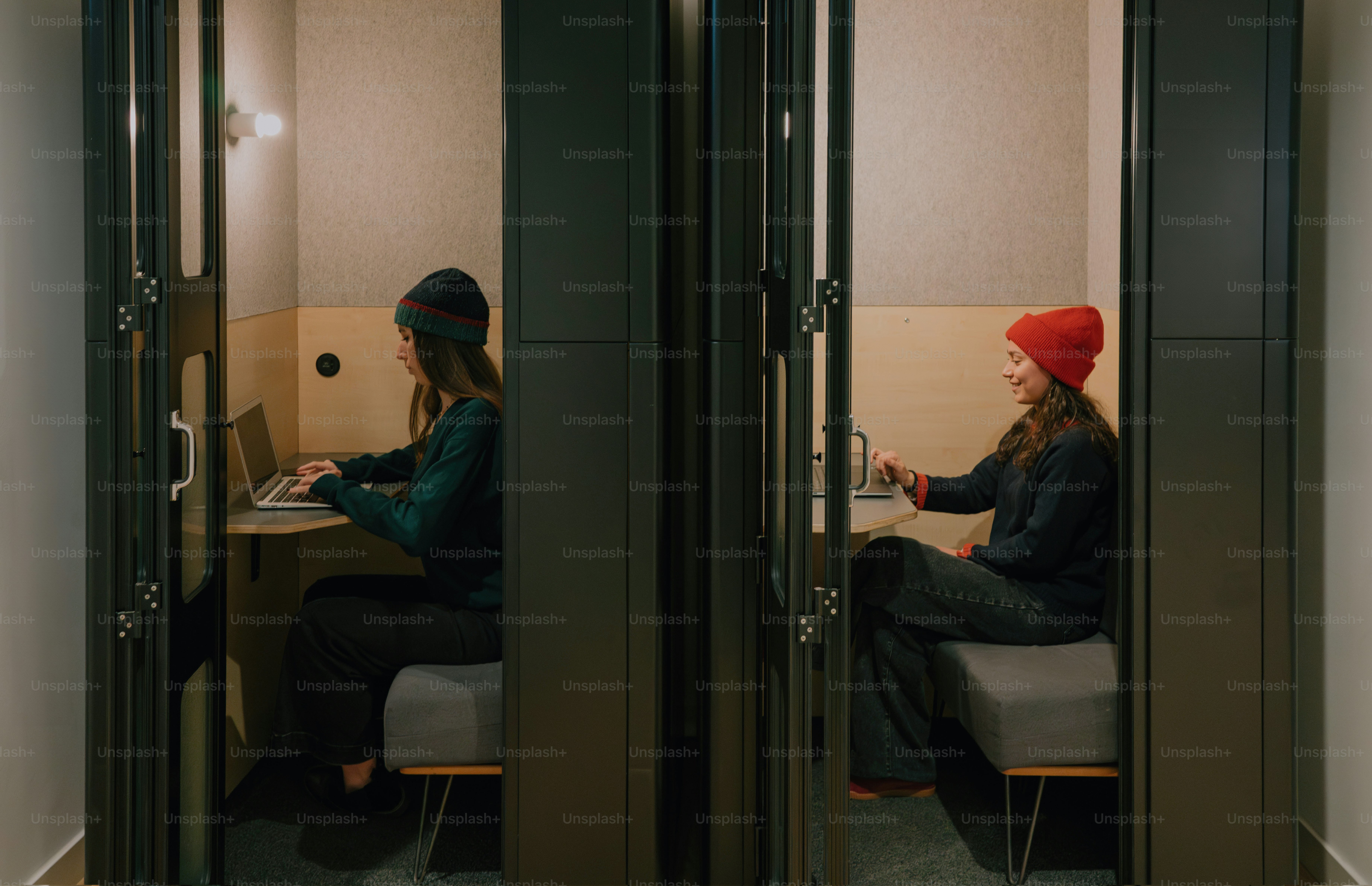 Two people work in separate, small booths.