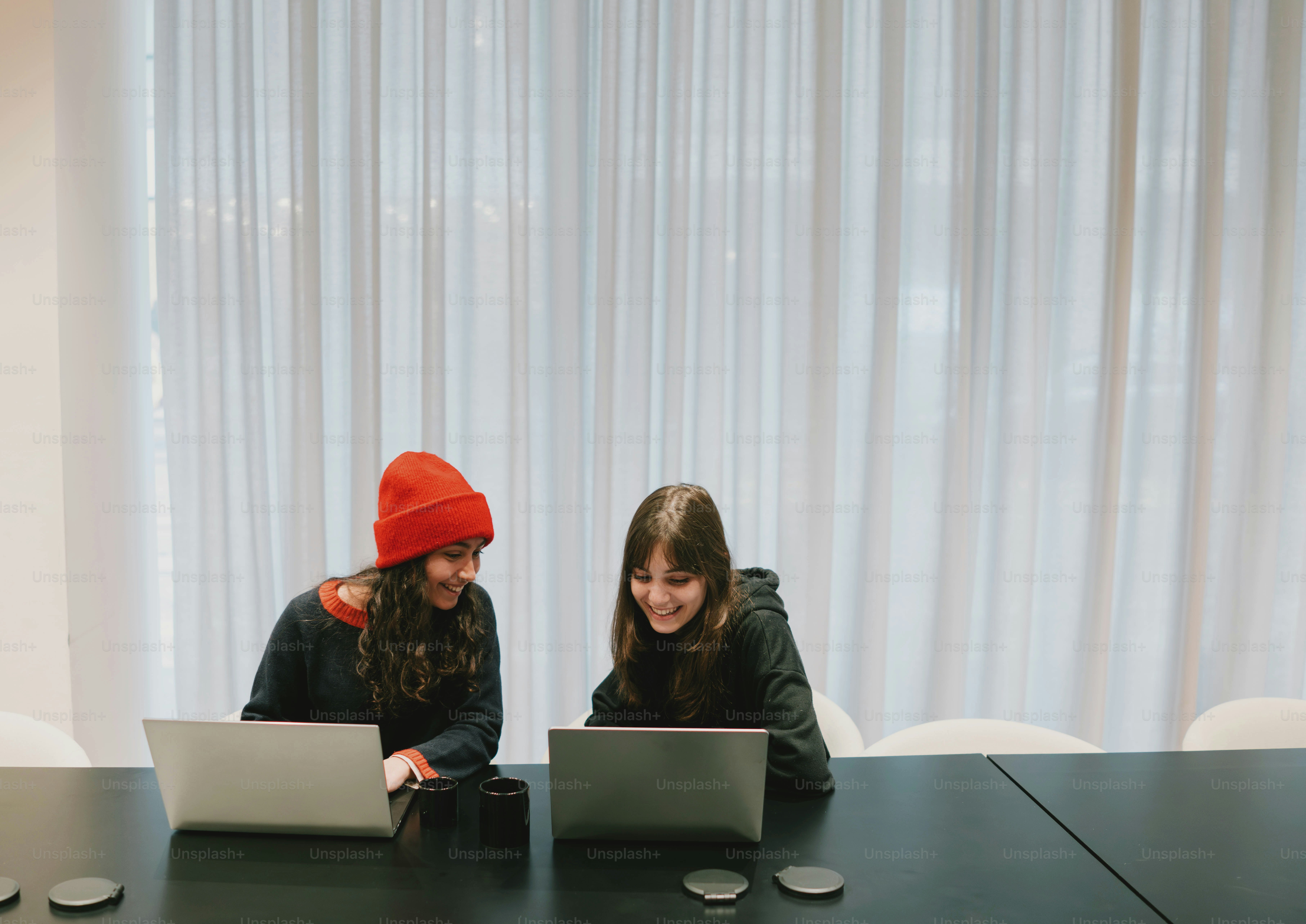 Two people are smiling while using laptops. photo – Business Image on ...