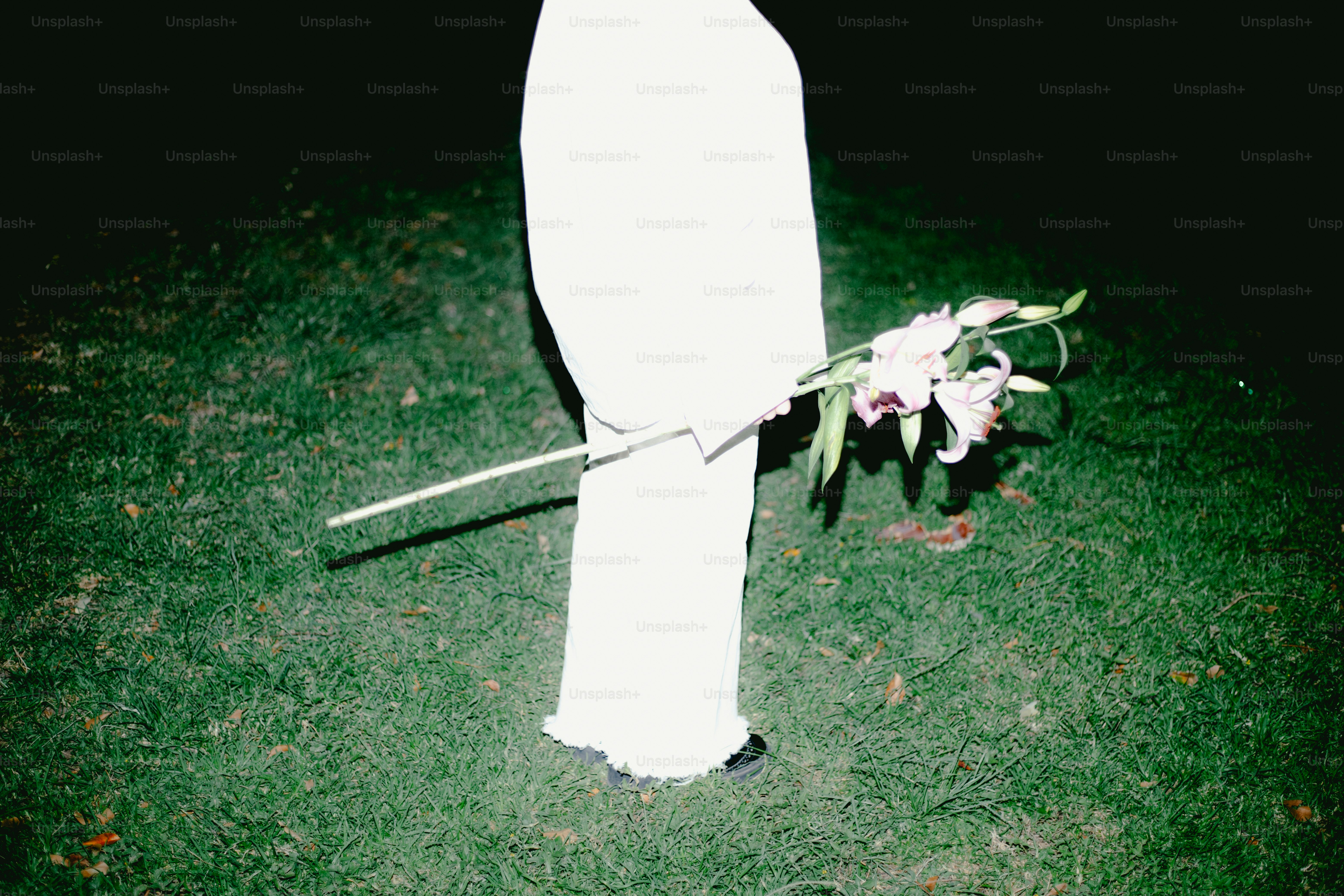 A figure in white holds a lily.