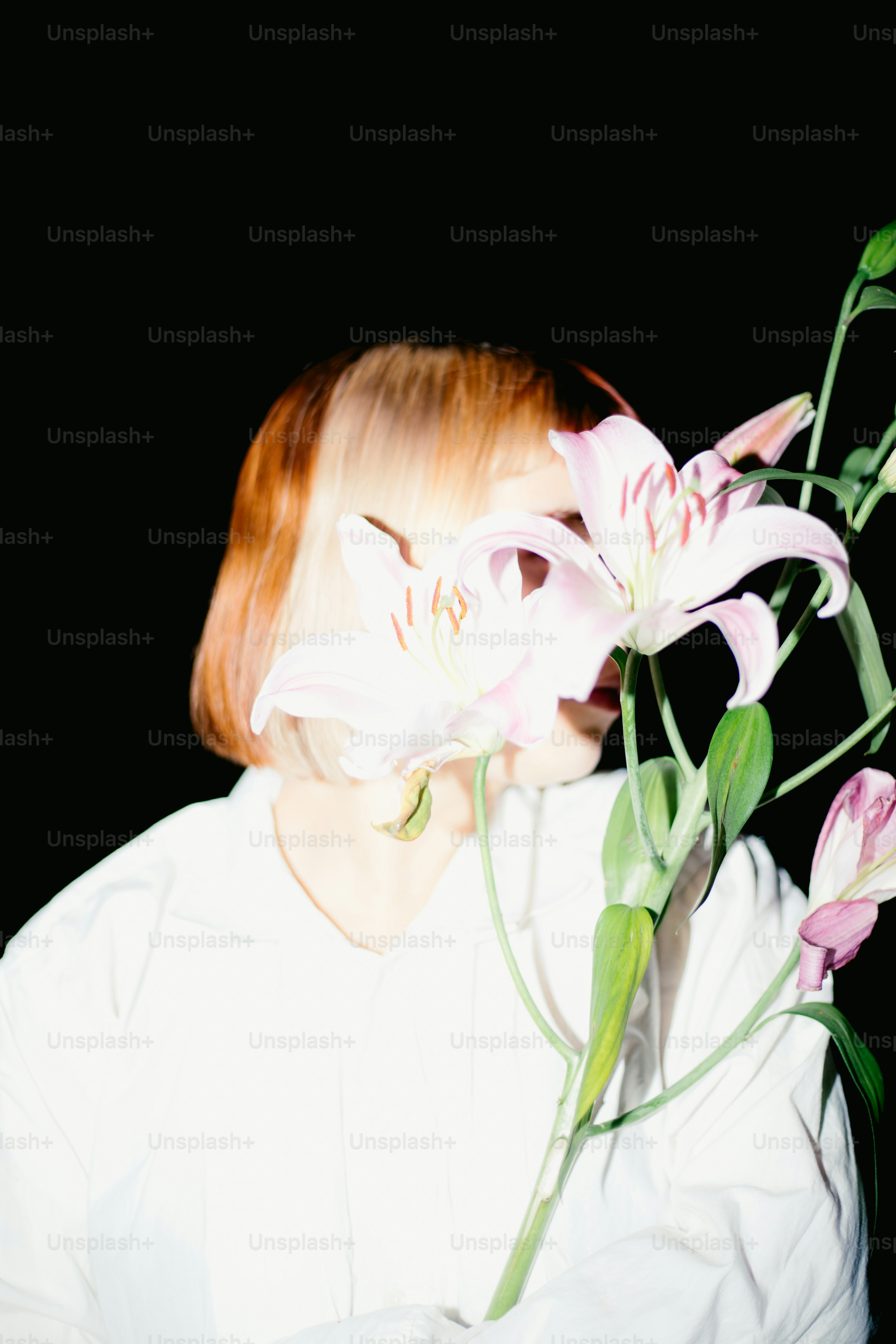 Woman obscured by flowers against a black background. photo – Flash ...