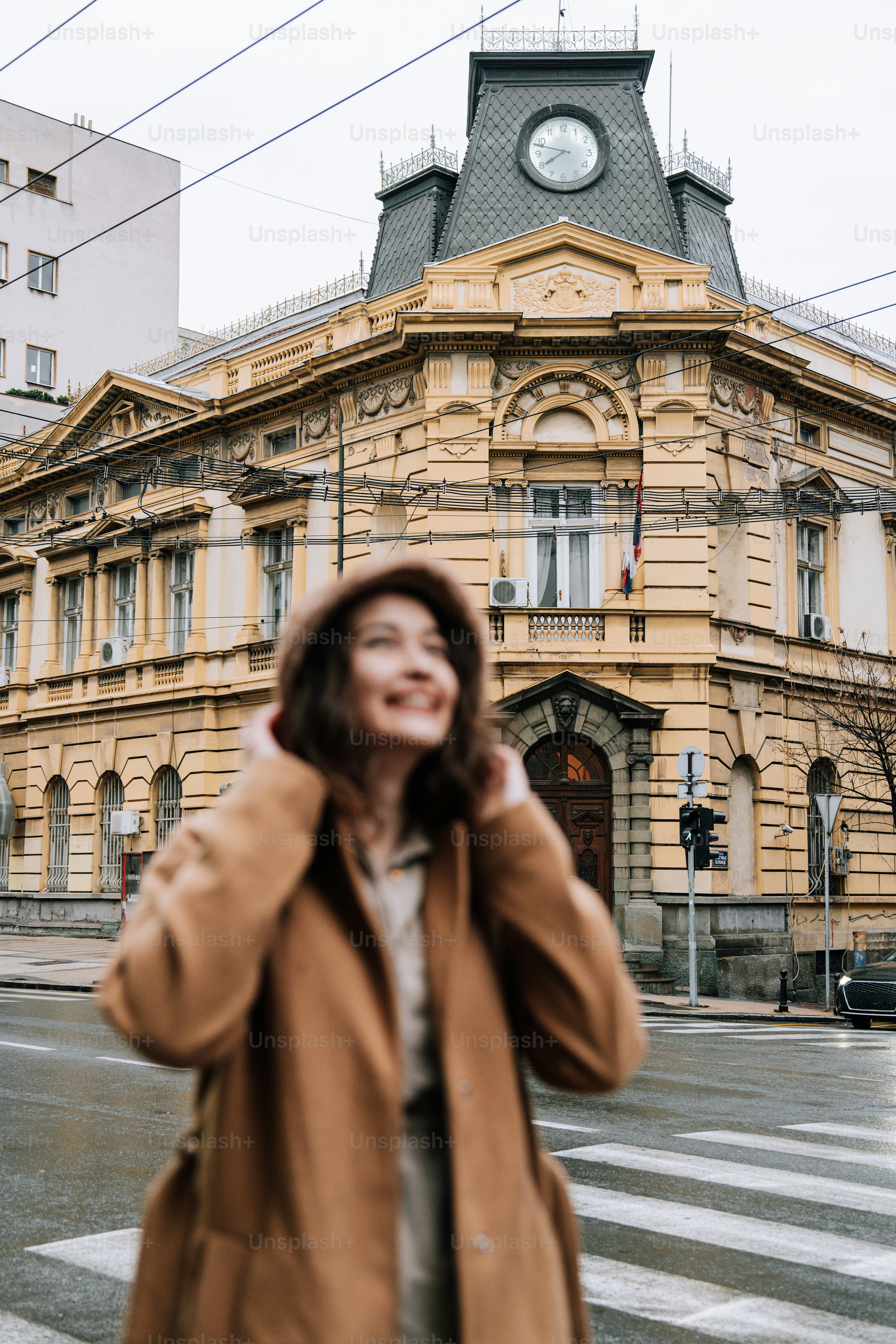 Woman smiles in front of a classic building.