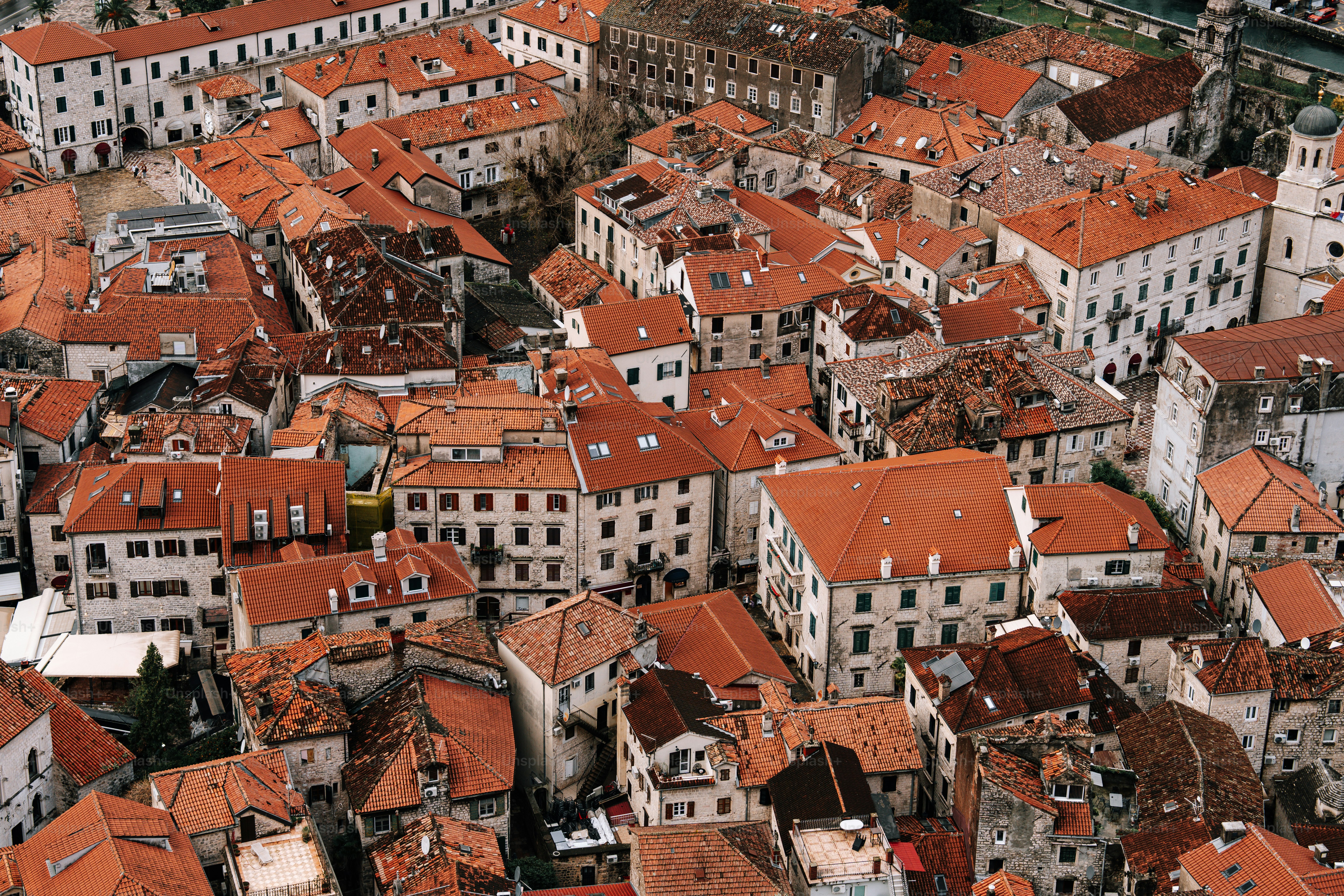 Cityscape with numerous red-tiled roofs and buildings.