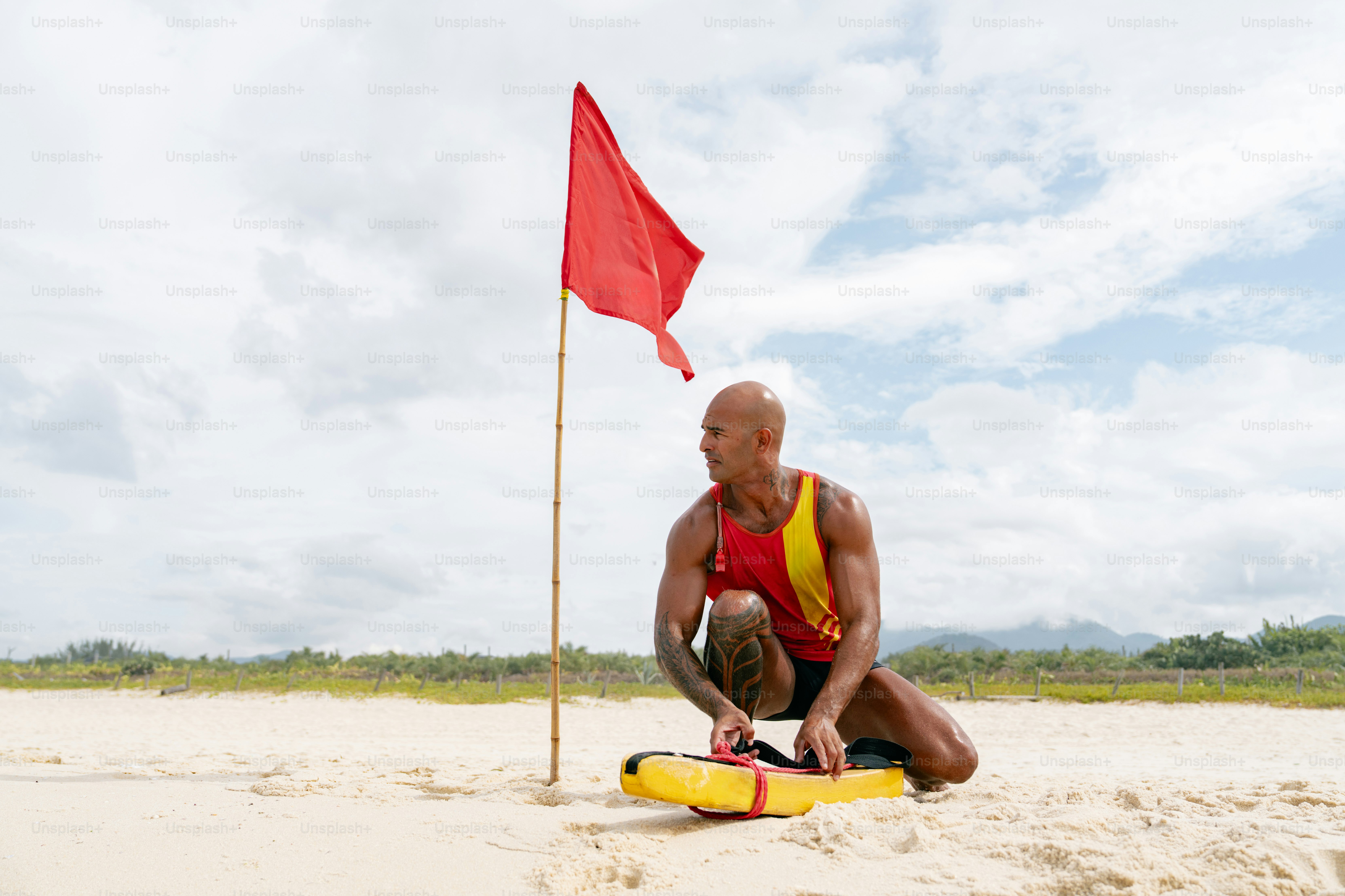 Lifeguard at the beach with a red flag.