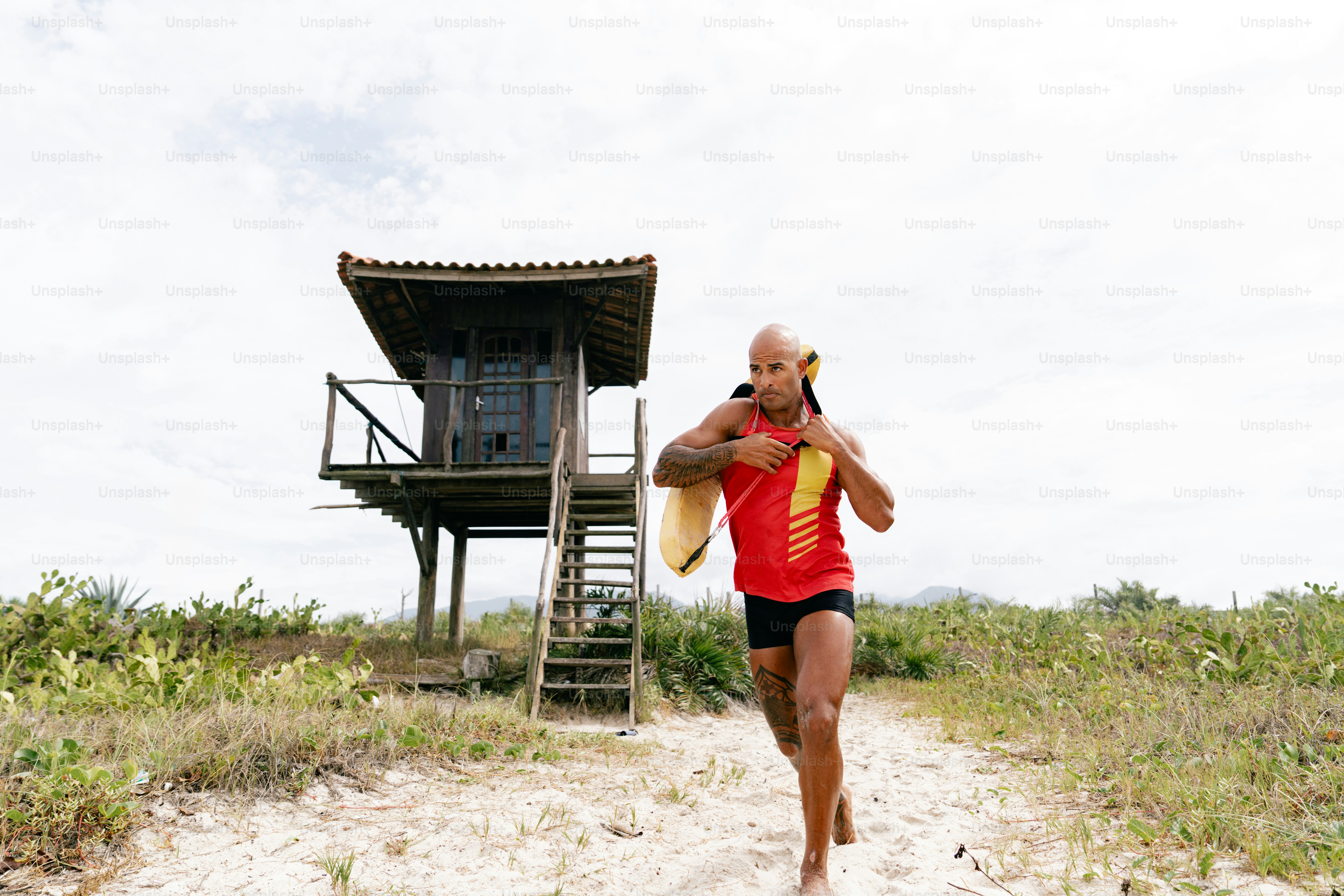 A man runs near a lifeguard tower.