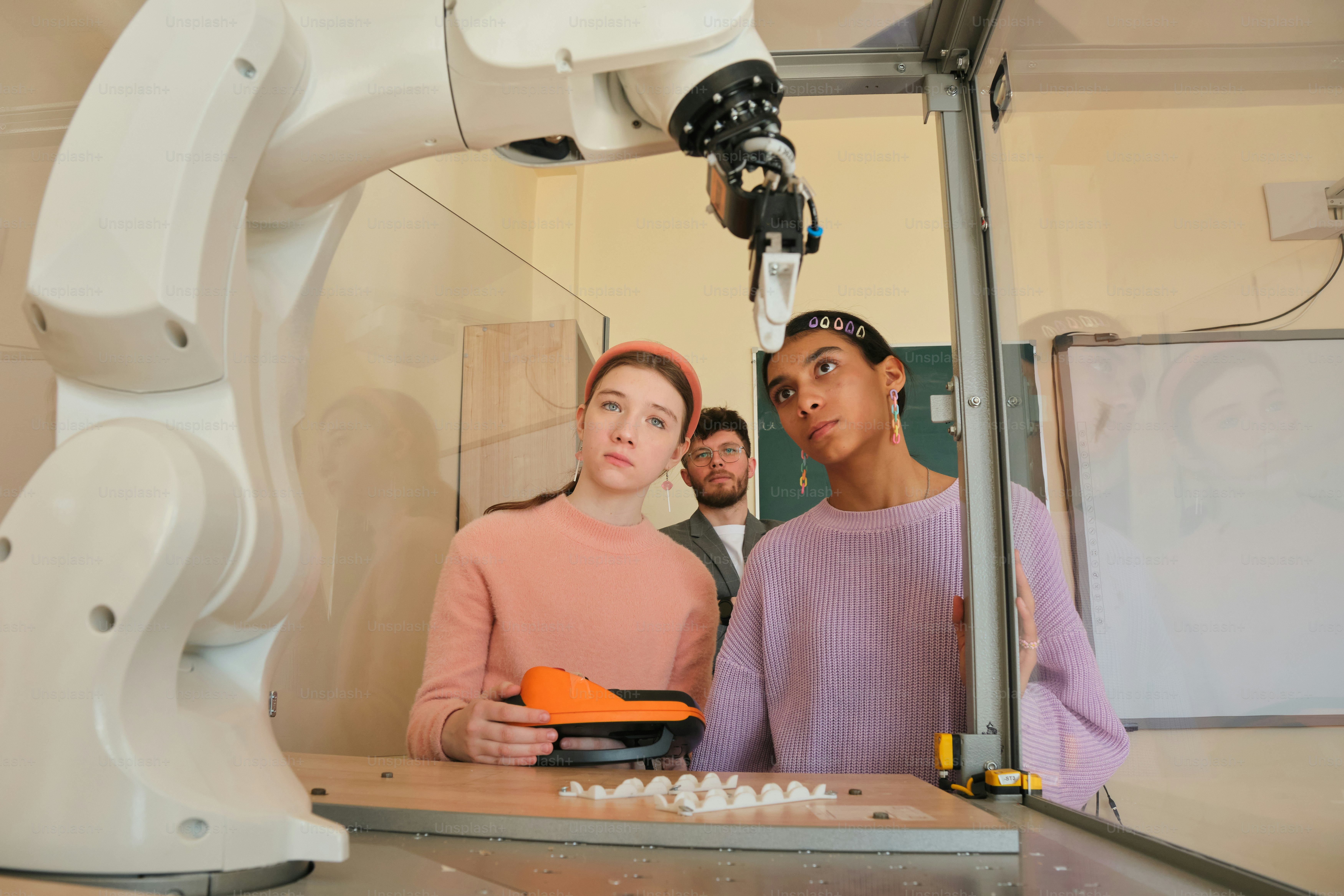 Students observe a robot arm in a lab. photo – Technology Image on Unsplash