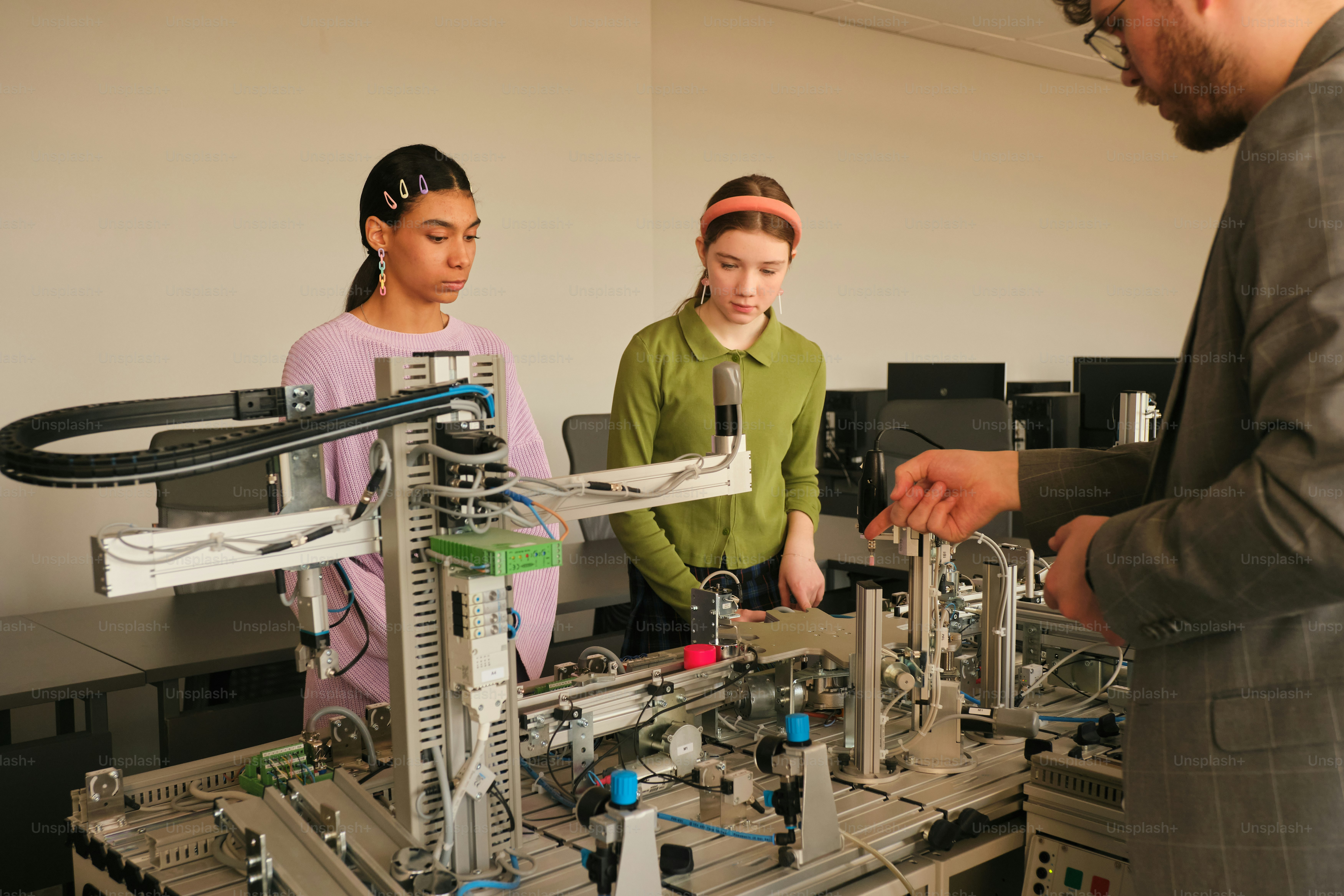 Students learn about robotics from a professor. photo – Technology ...