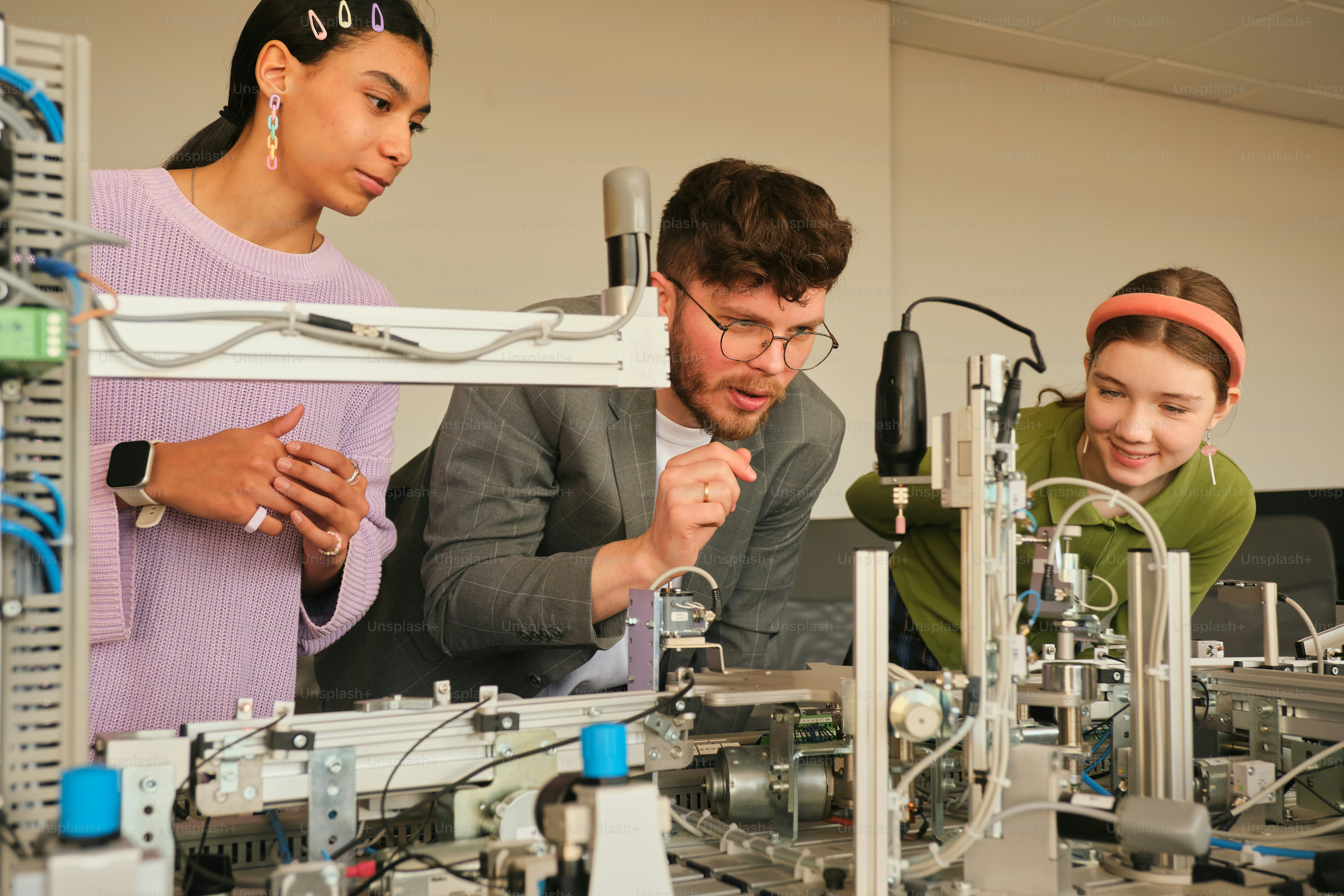 People are examining machinery together in a lab. photo – Technology ...