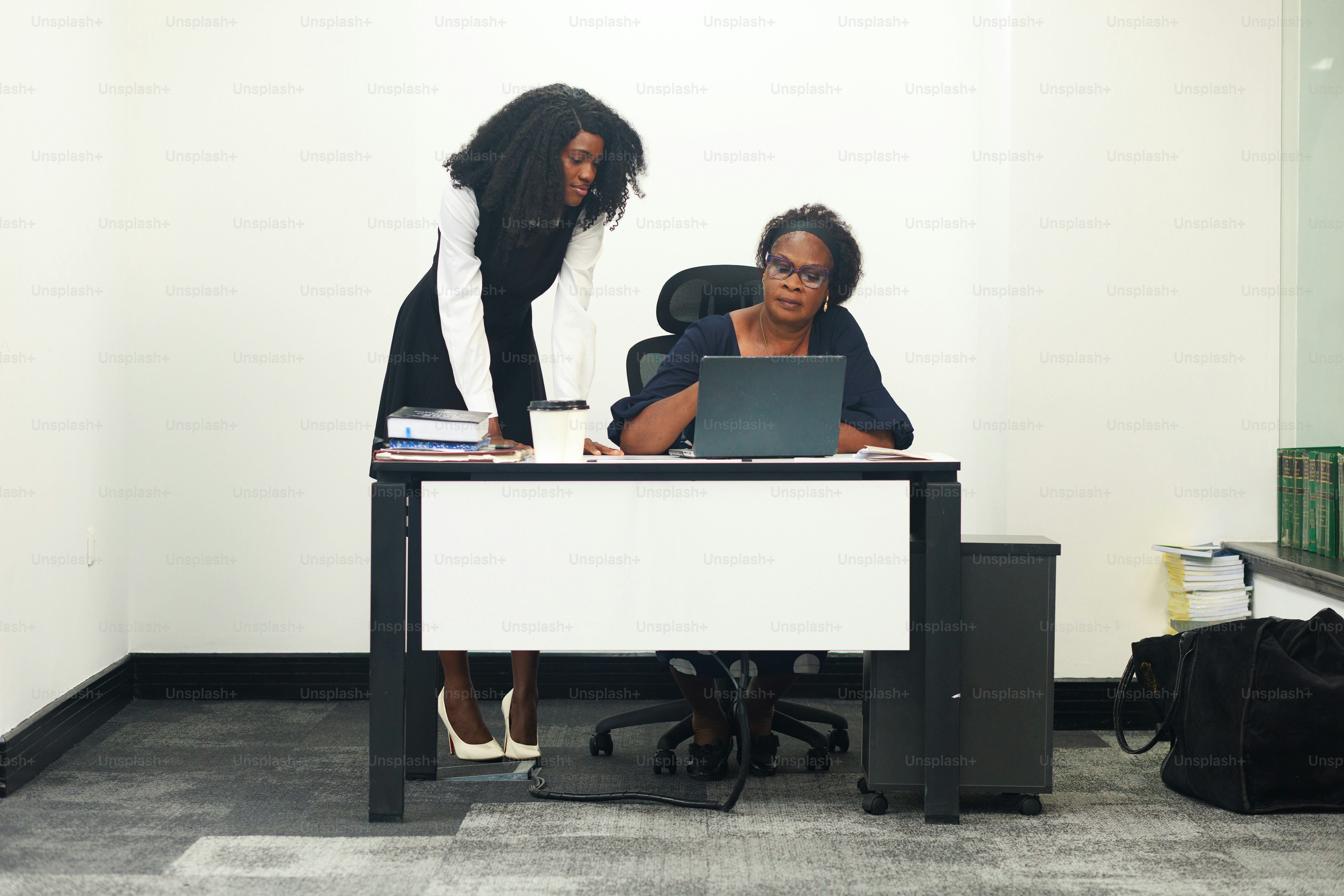 Two women collaborate at a desk.