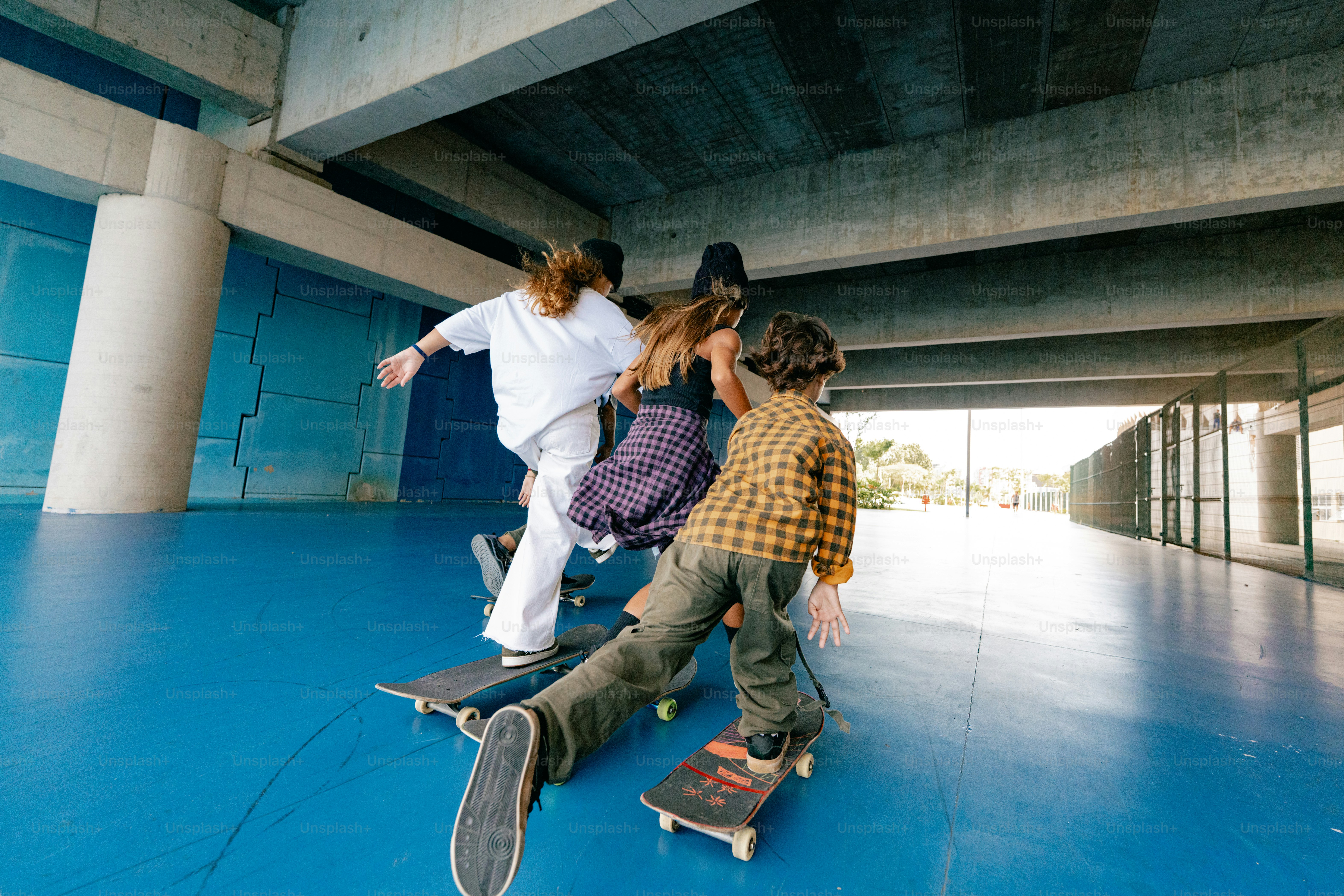 Gente patinando debajo de un puente.