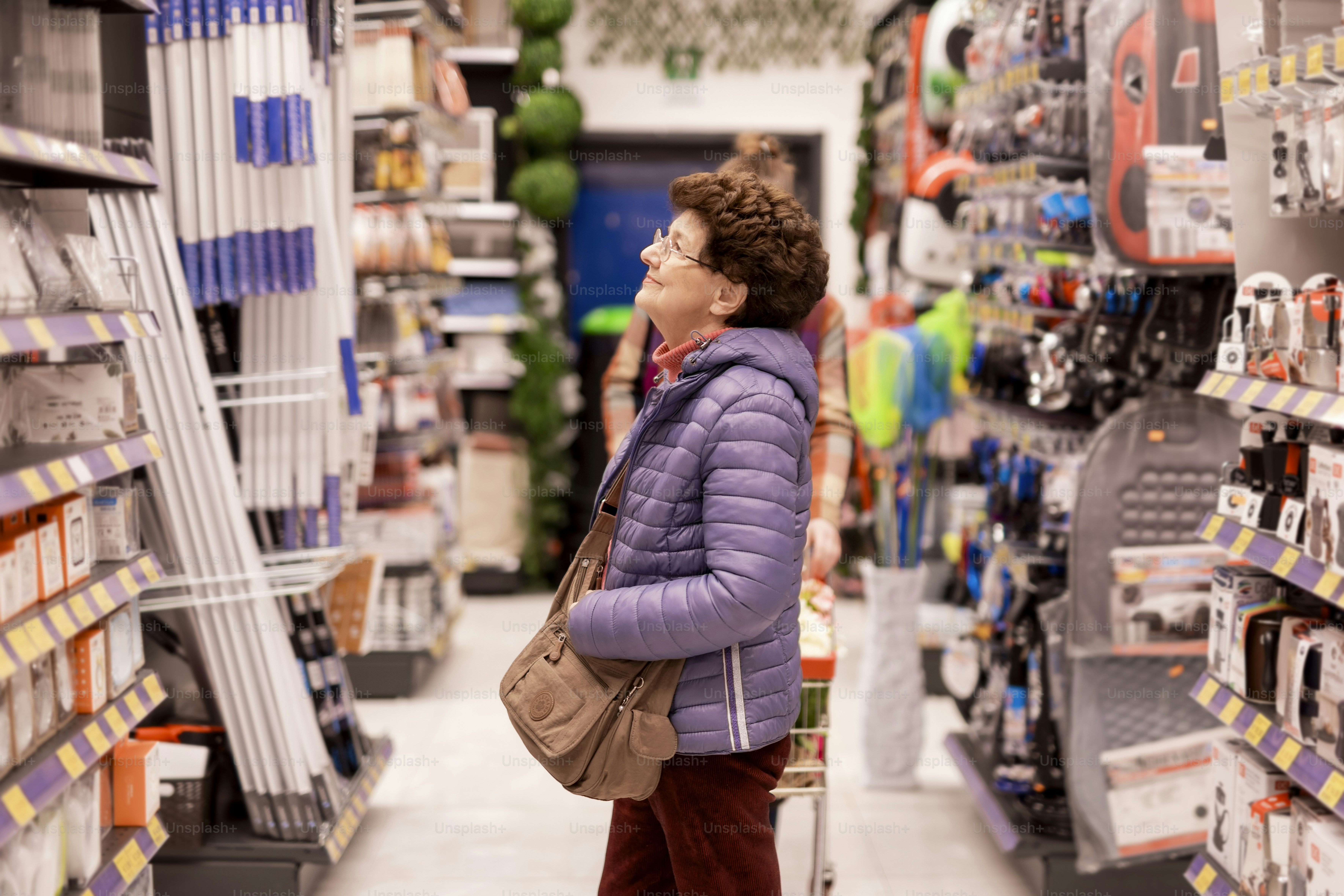 Woman browses items in a busy, well-stocked store aisle.