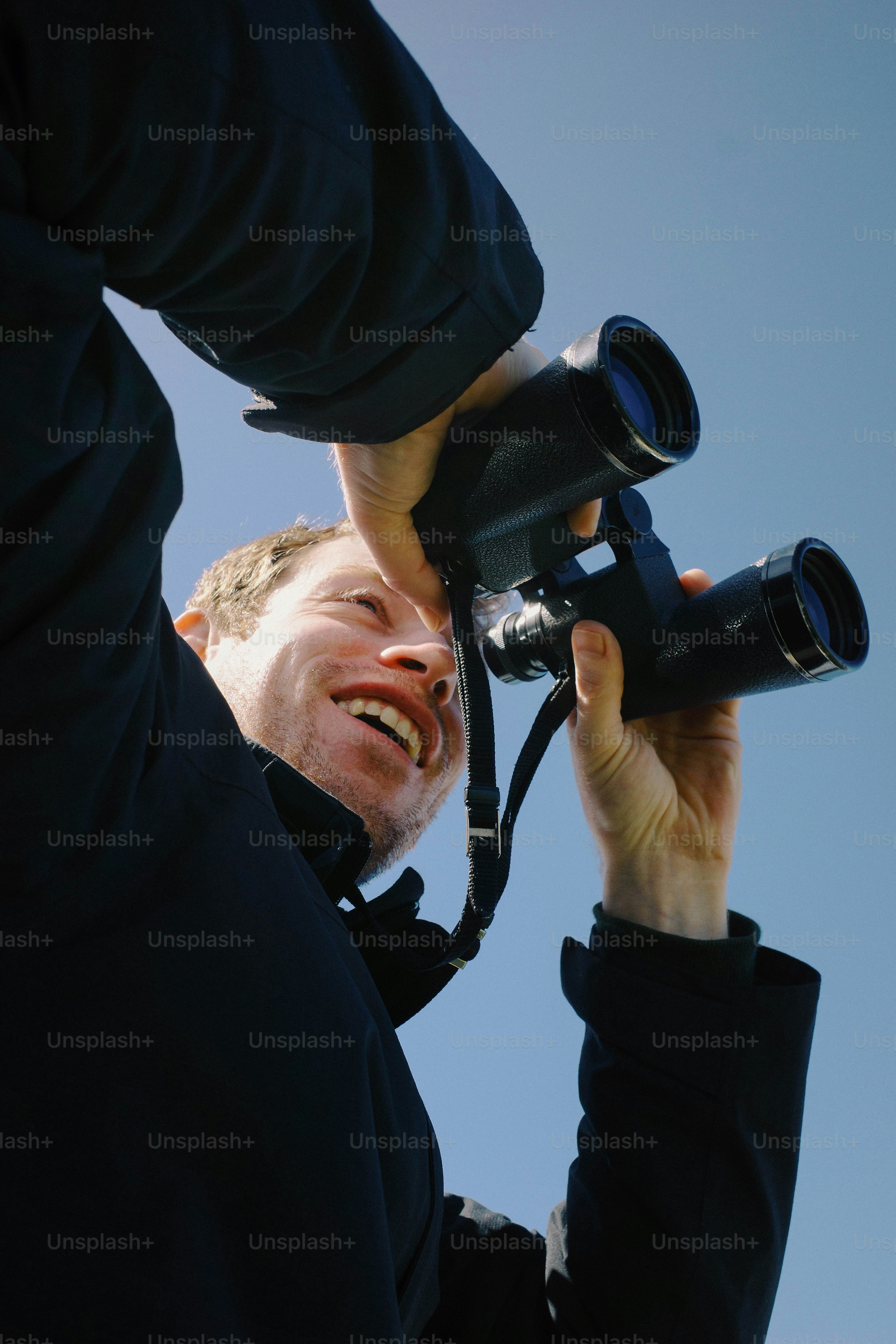 L'uomo sorride mentre guarda attraverso il binocolo.