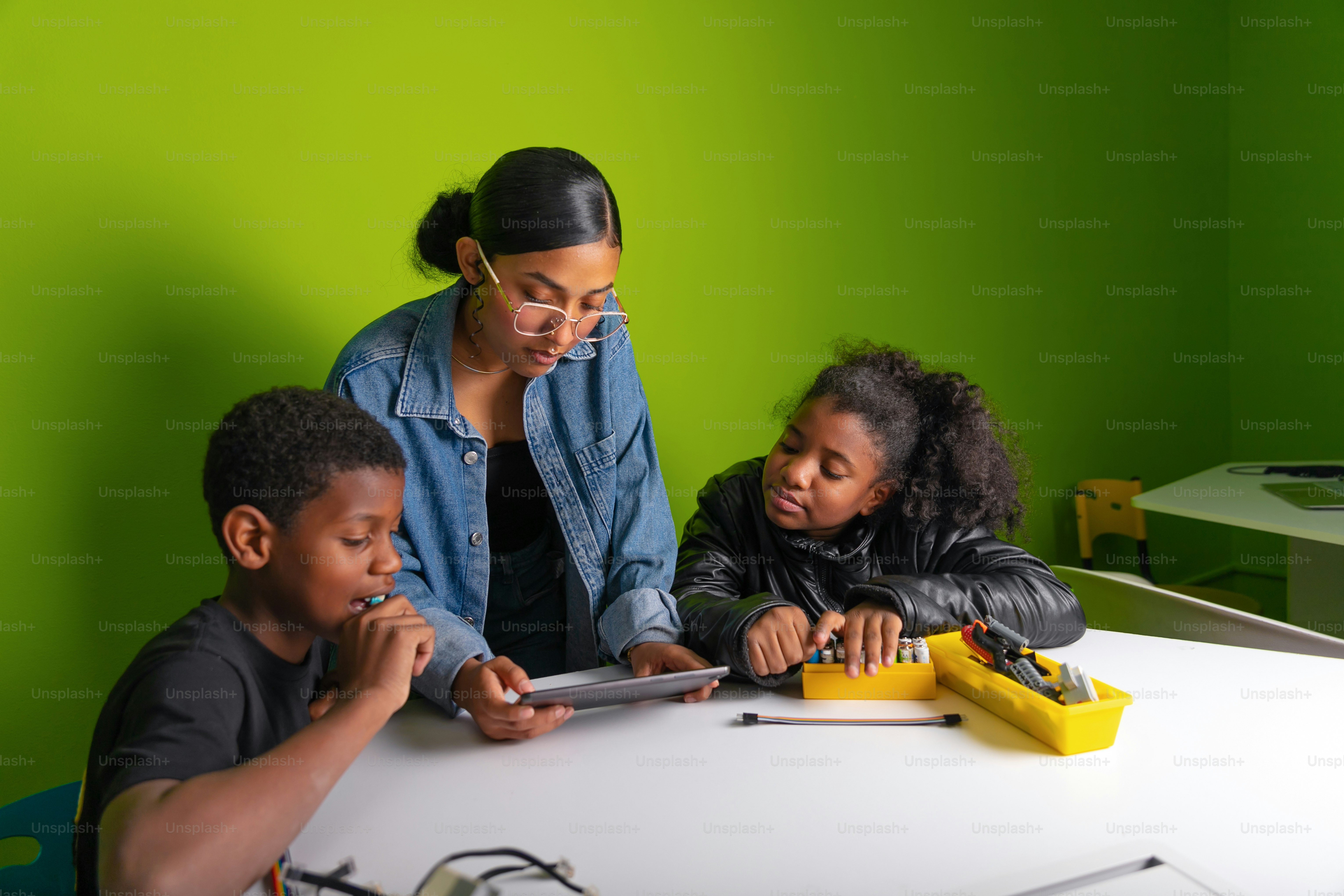 A teacher helps students with their tablet. photo – Technology Image on ...
