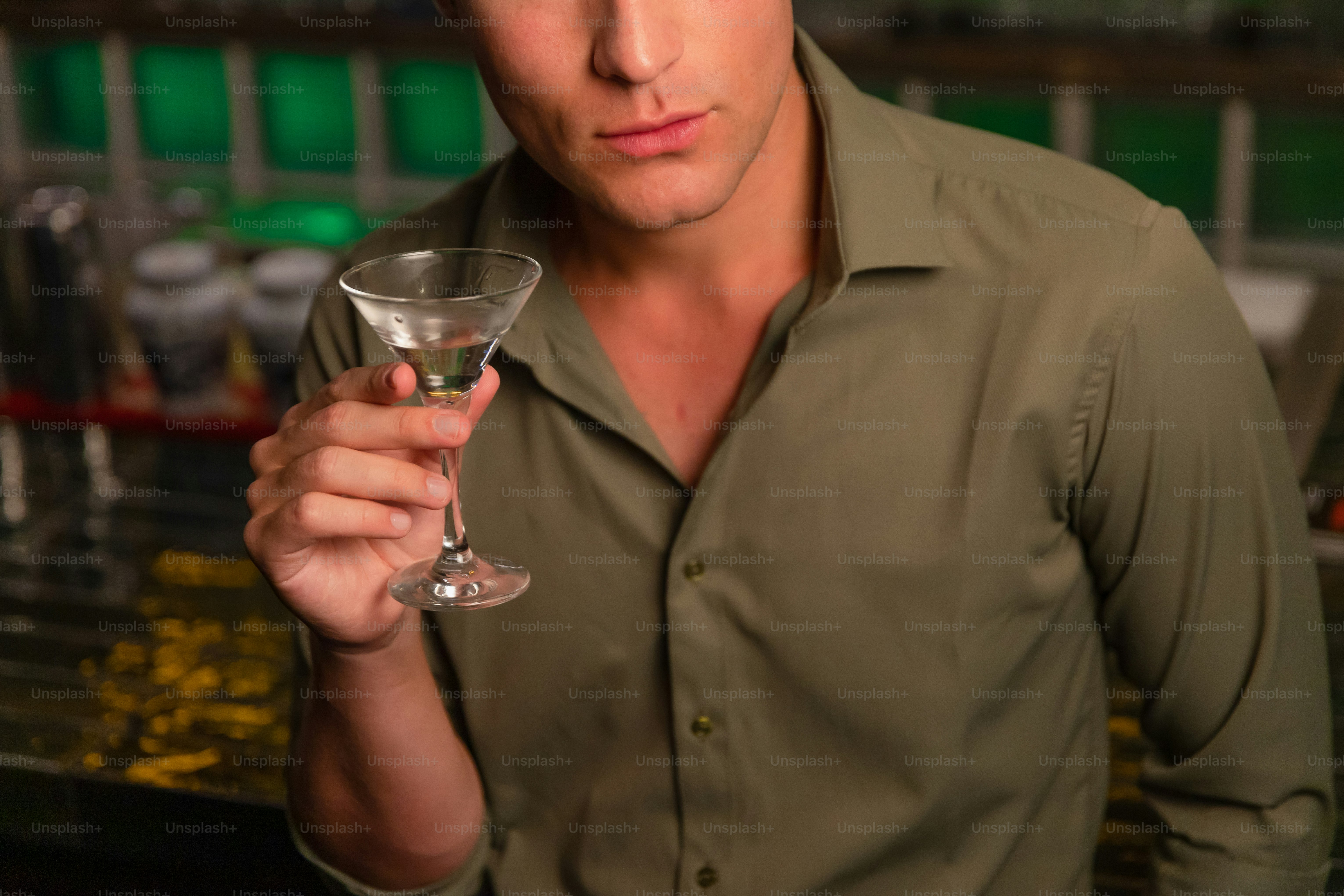 A man holds a martini glass.