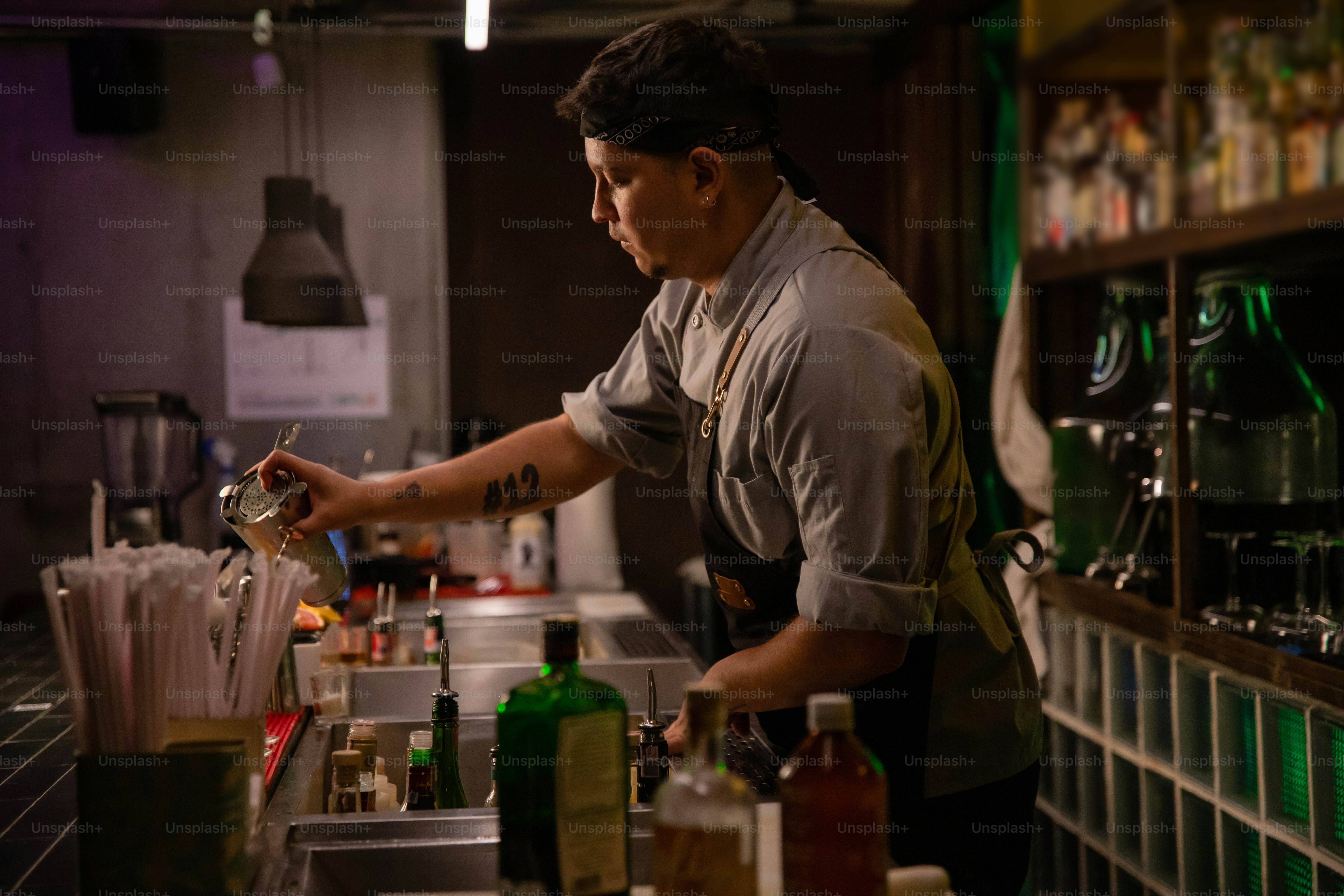 A bartender is making a drink at the bar.