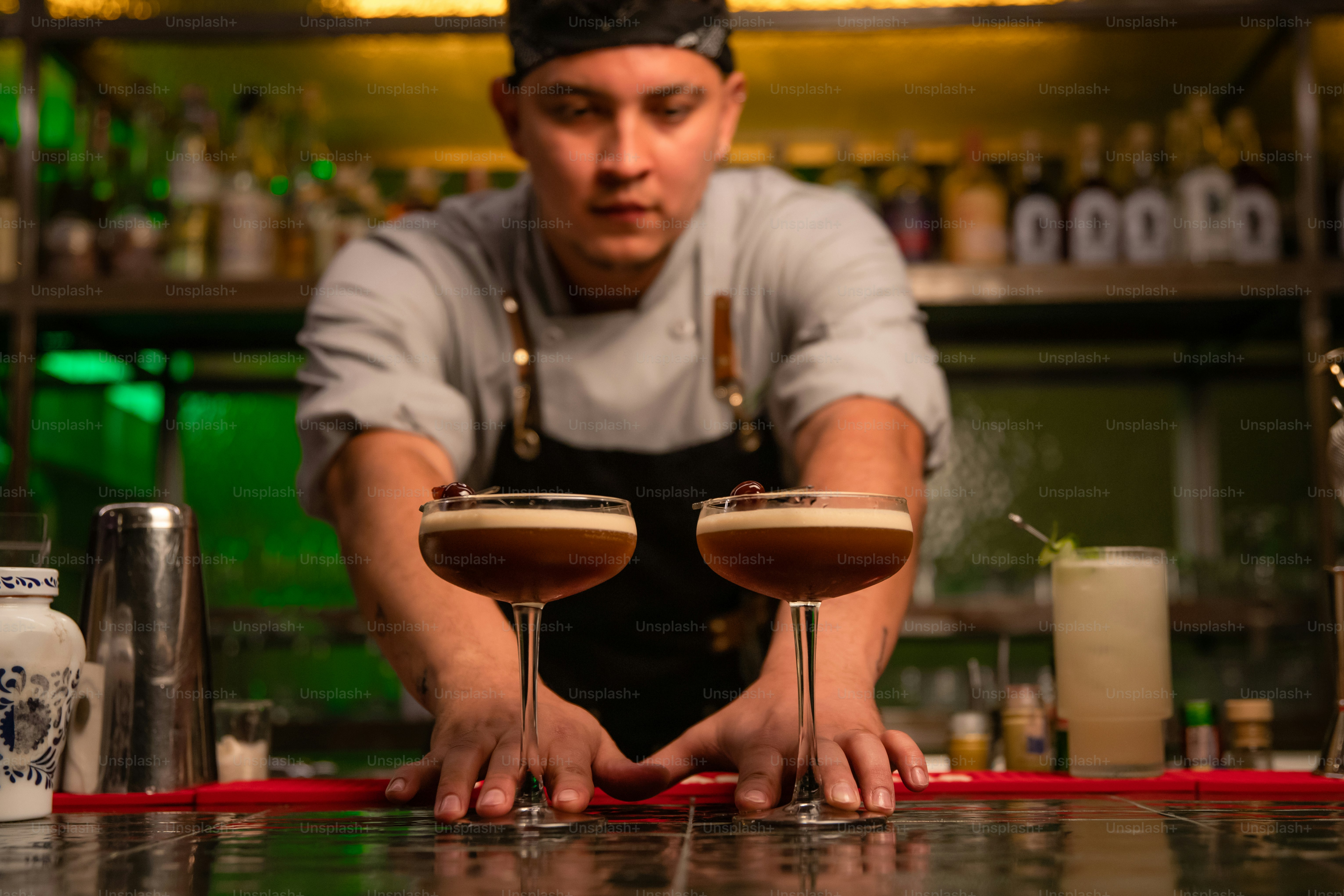 Bartender presents two espresso martinis for the camera.