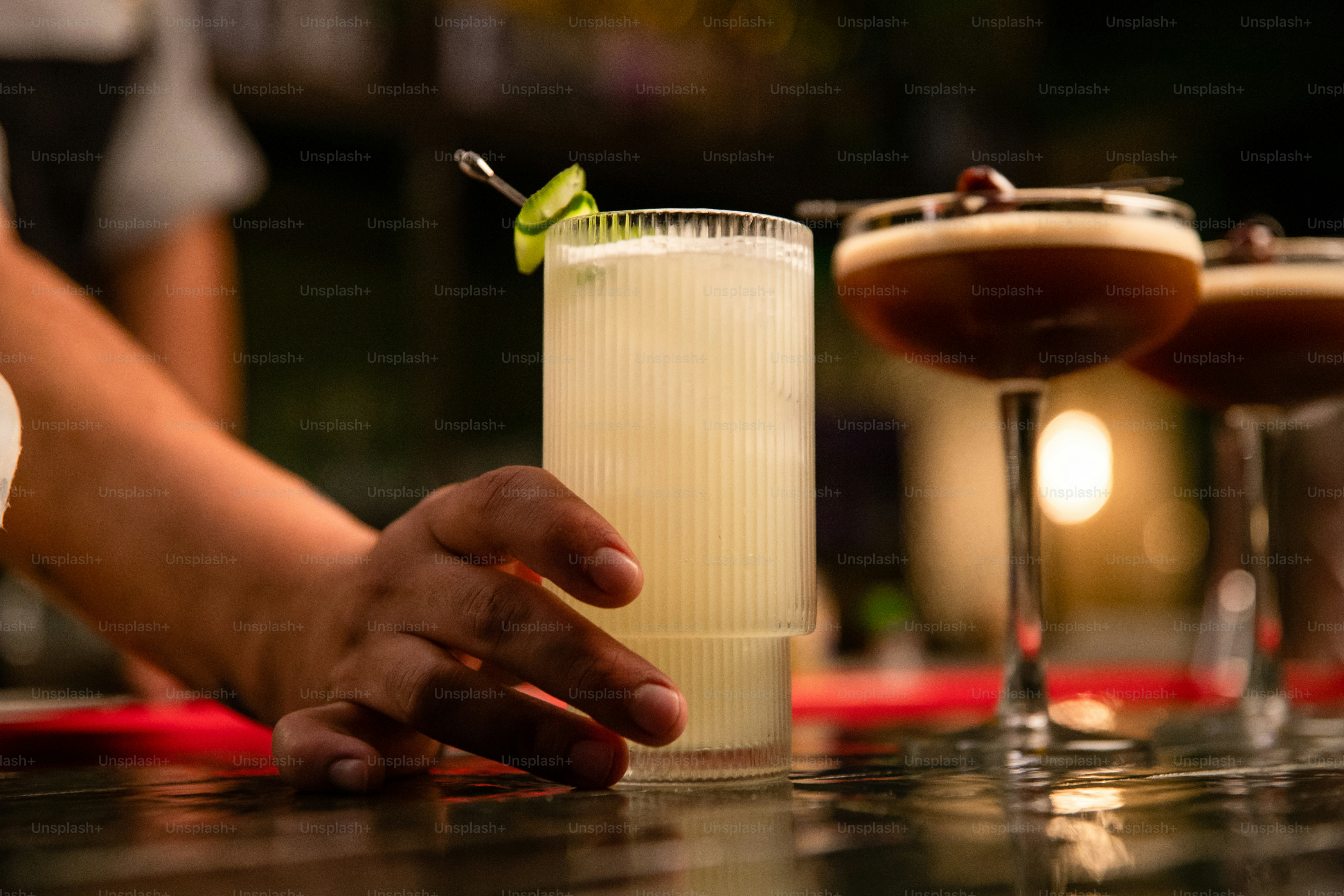 A bartender prepares cocktails at the bar.