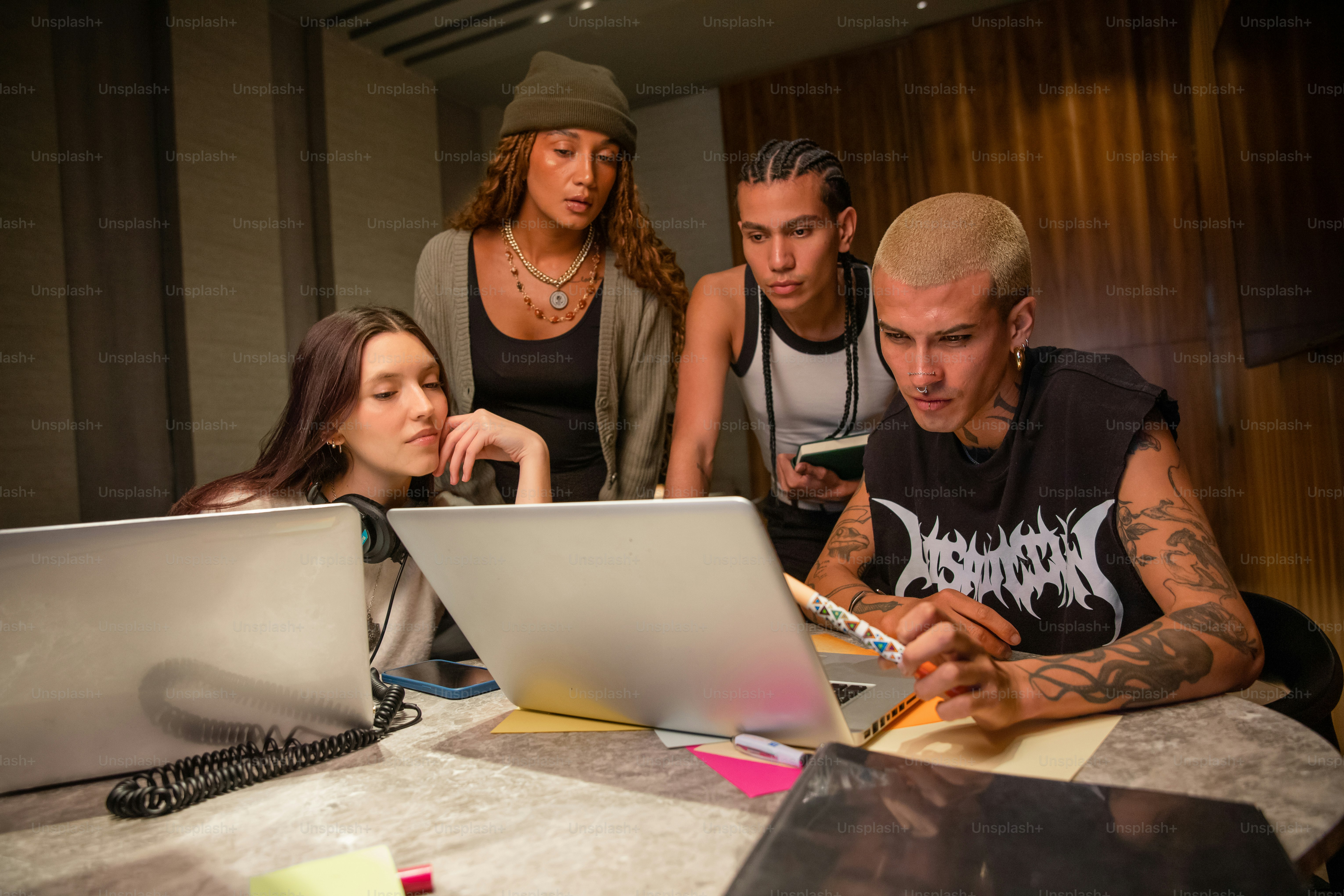 Young adults collaborate around a laptop computer