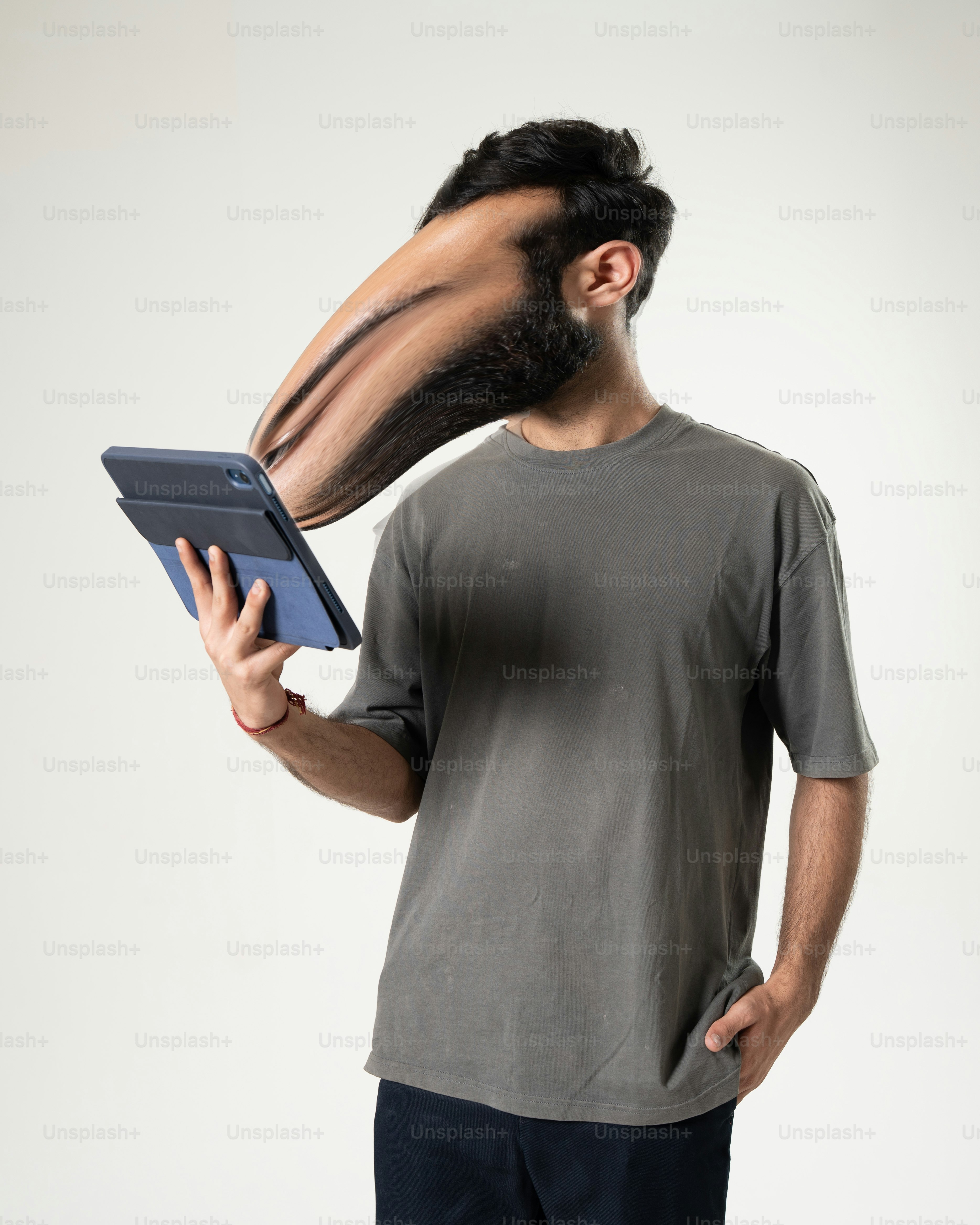 Das Gesicht des Mannes ist verzerrt, während er ein Tablet benutzt.