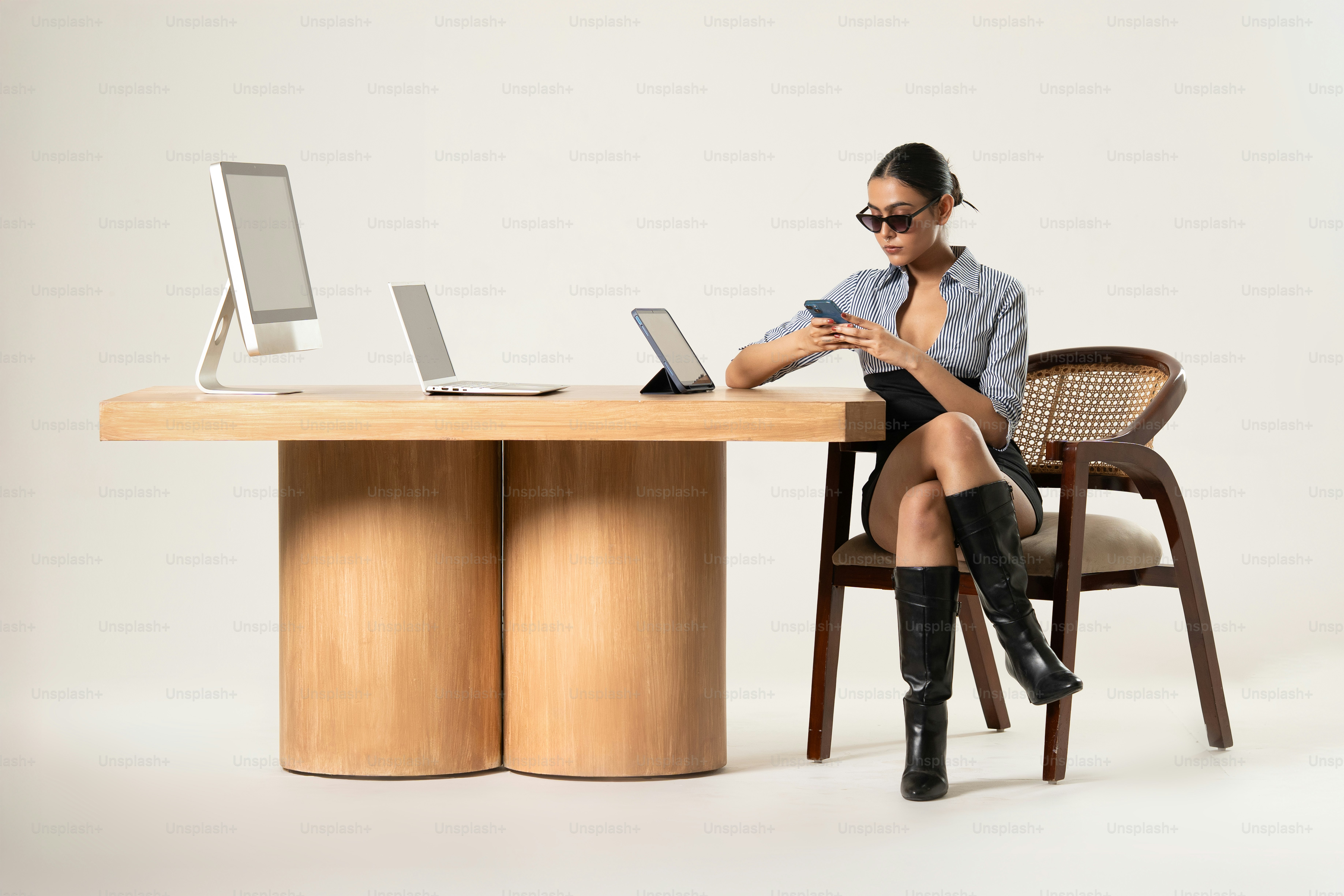 Una mujer elegante trabaja con gadgets en un escritorio.