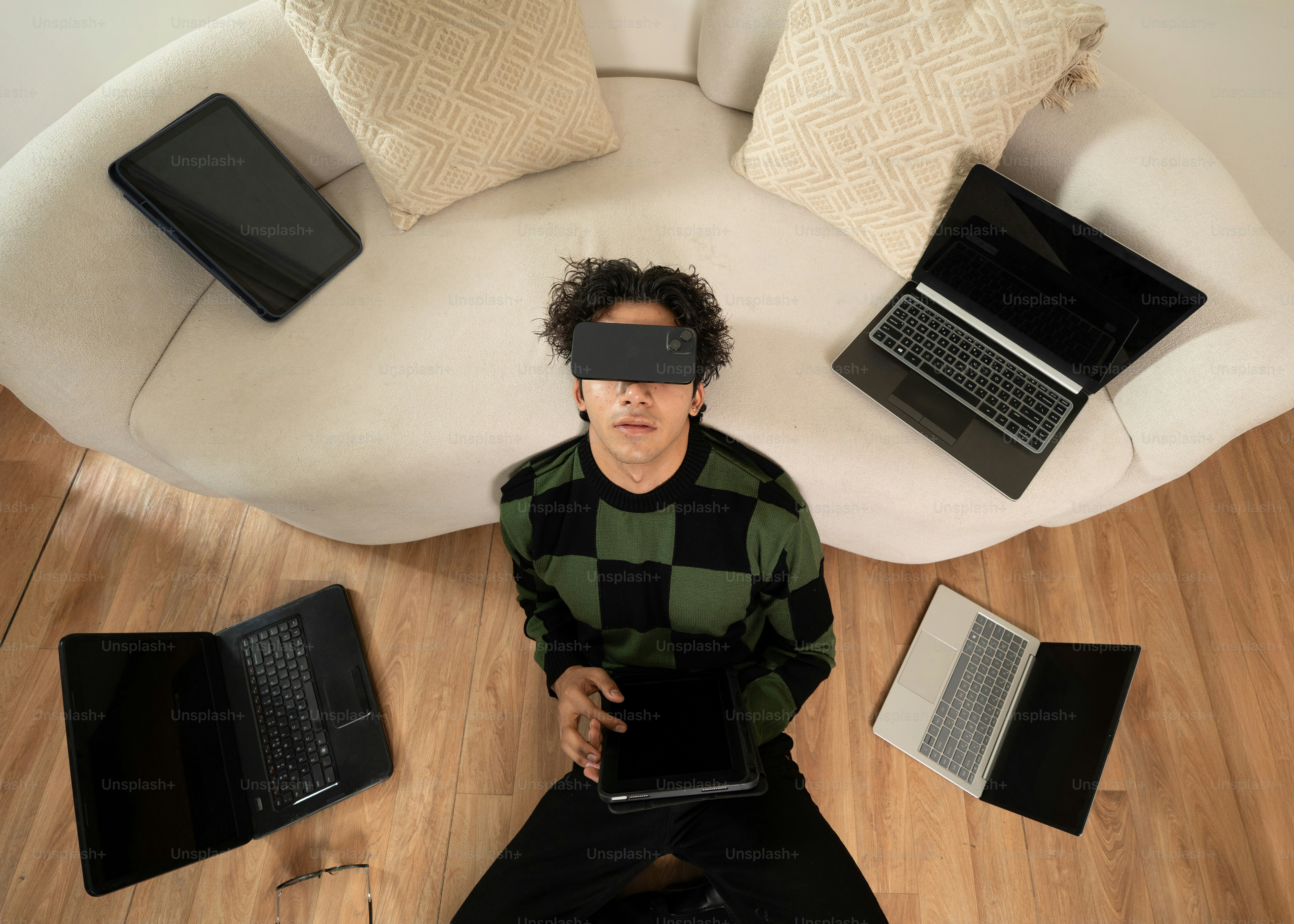 Una persona está rodeada de pantallas y tecnología.