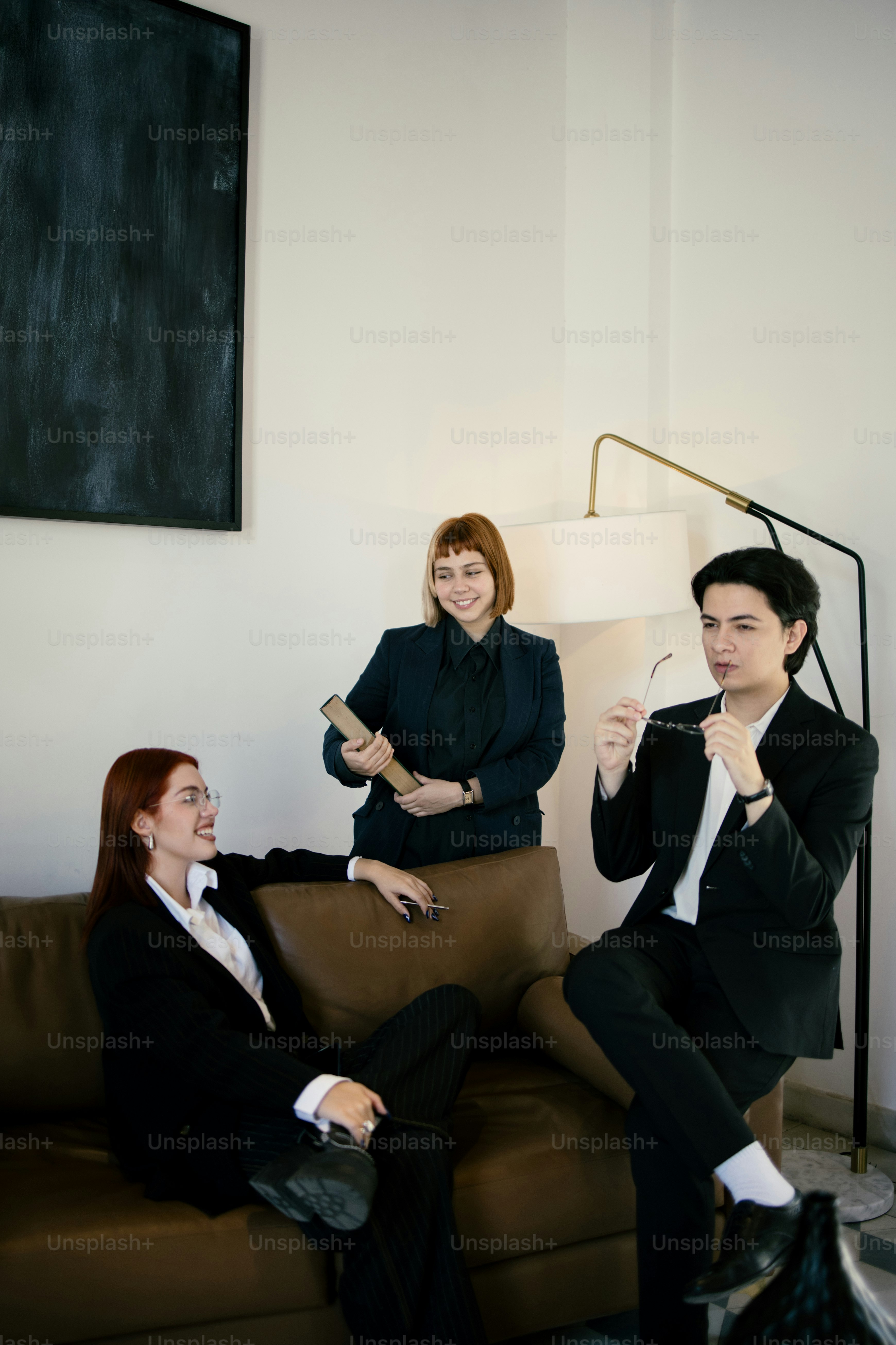 Business professionals are conversing in a relaxing office.