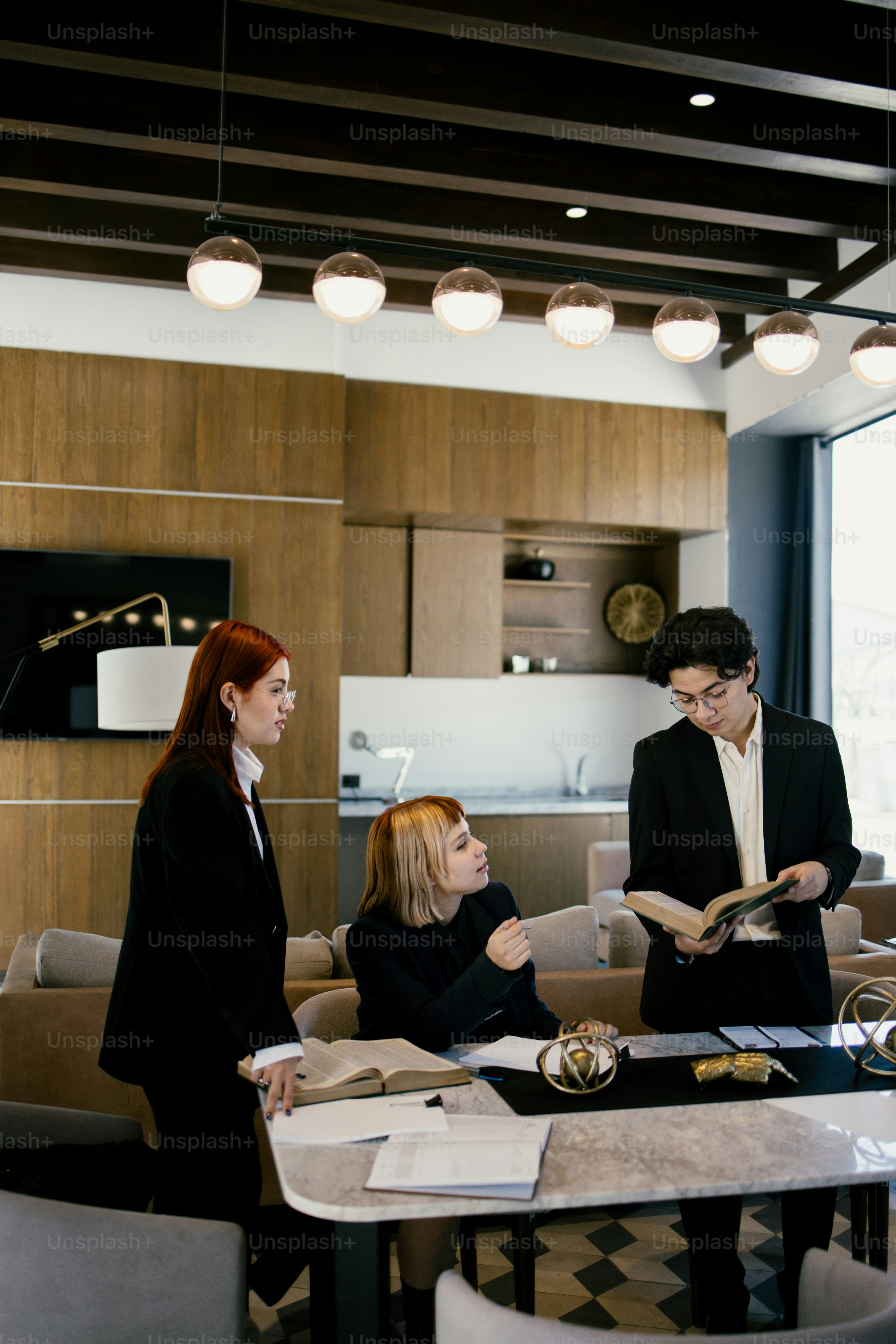 Three professionals collaborate in an office meeting.