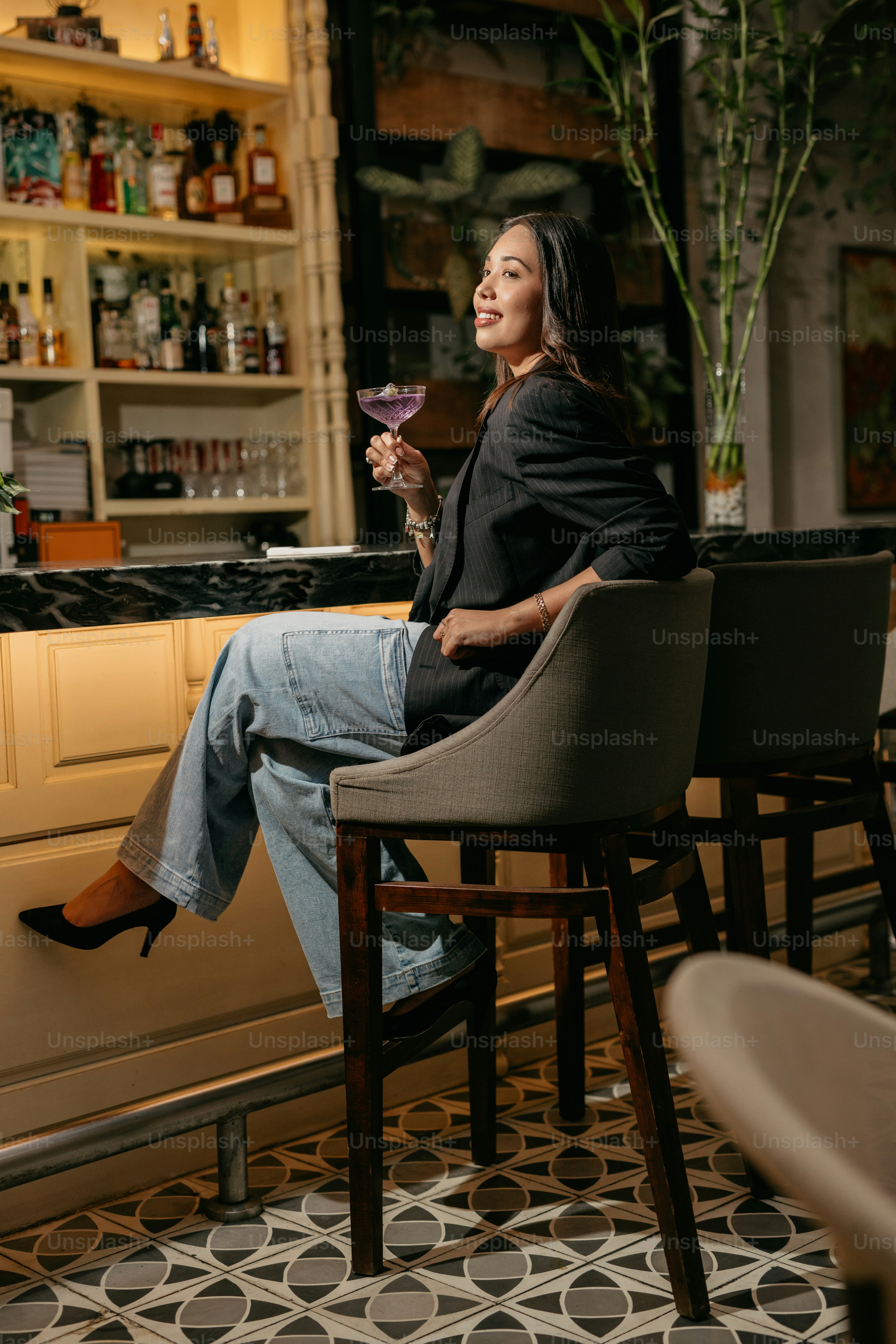 Woman enjoys a drink at a bar, smiling. photo – Bar Image on Unsplash