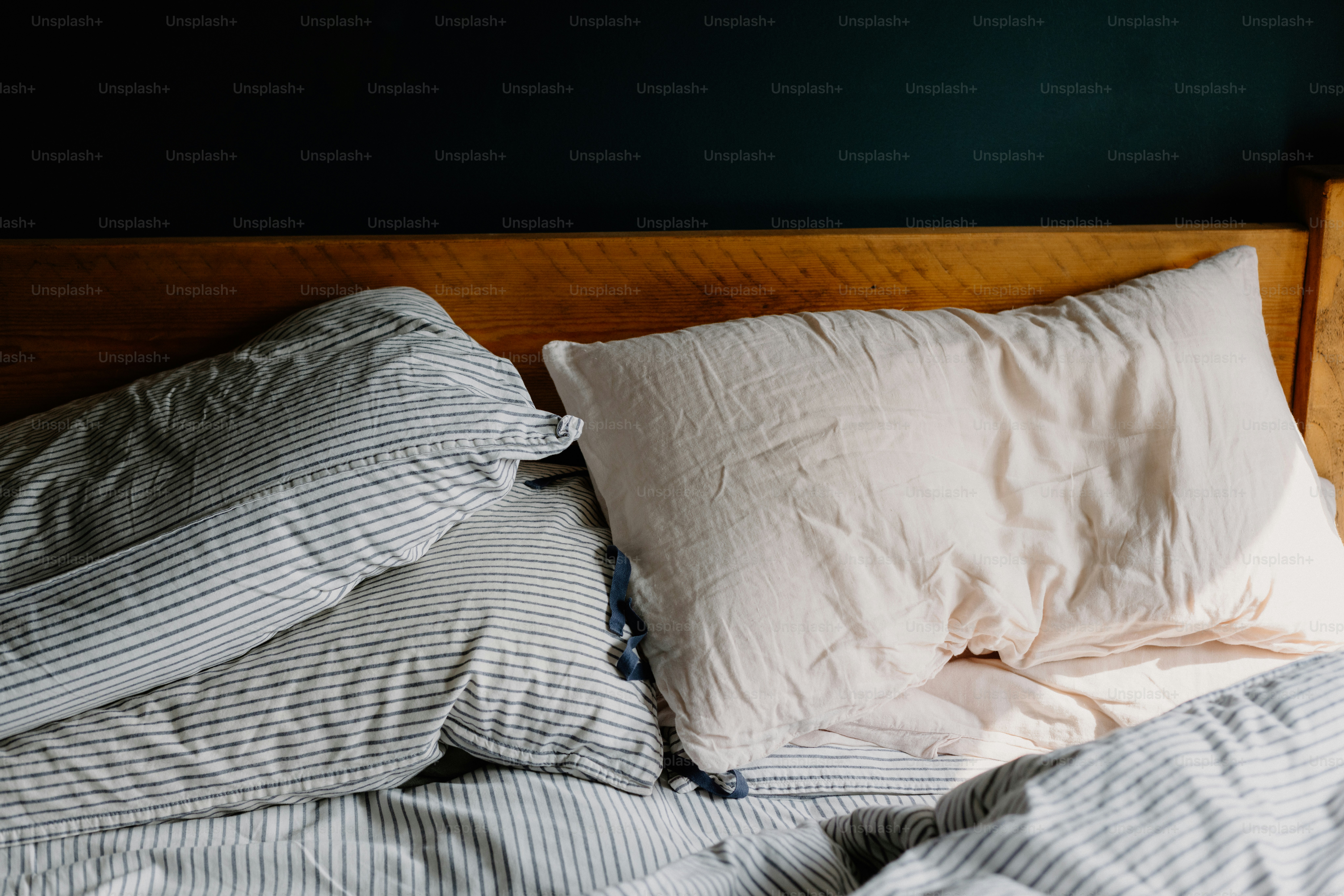 Gemütliches Bett mit Kissen und Kopfteil aus Holz