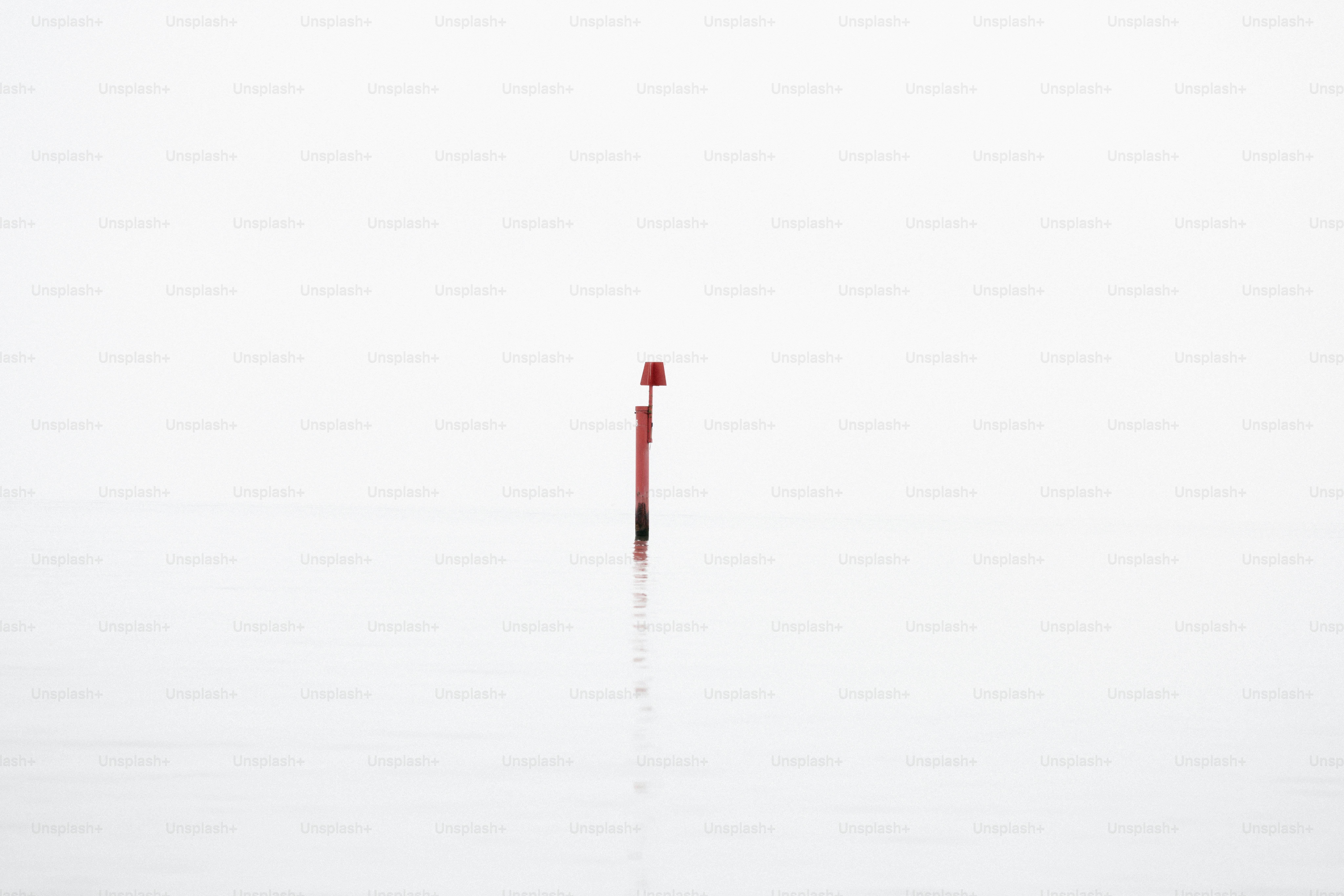 A red beacon stands against white.