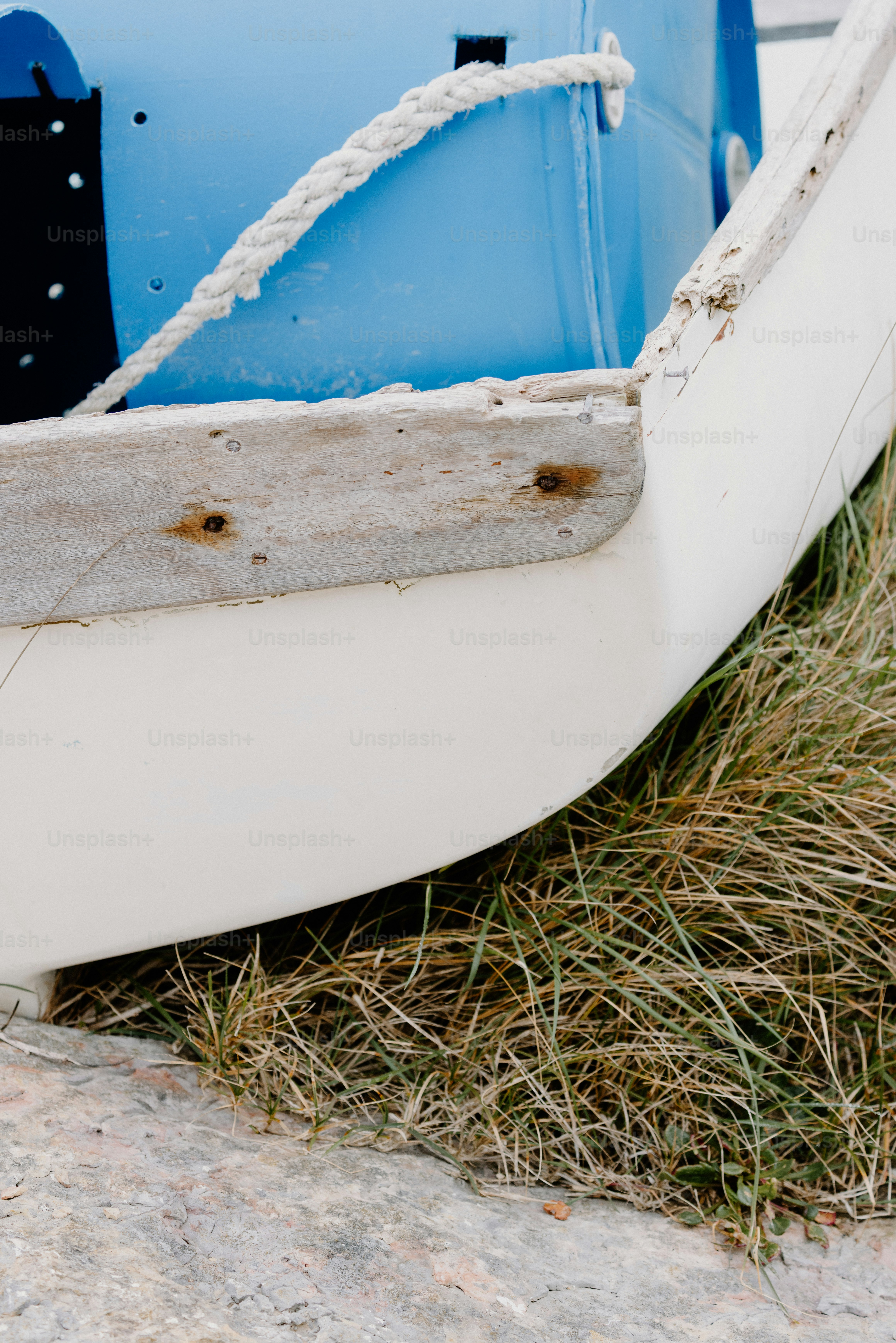 The boat's bow rests against dry grass.