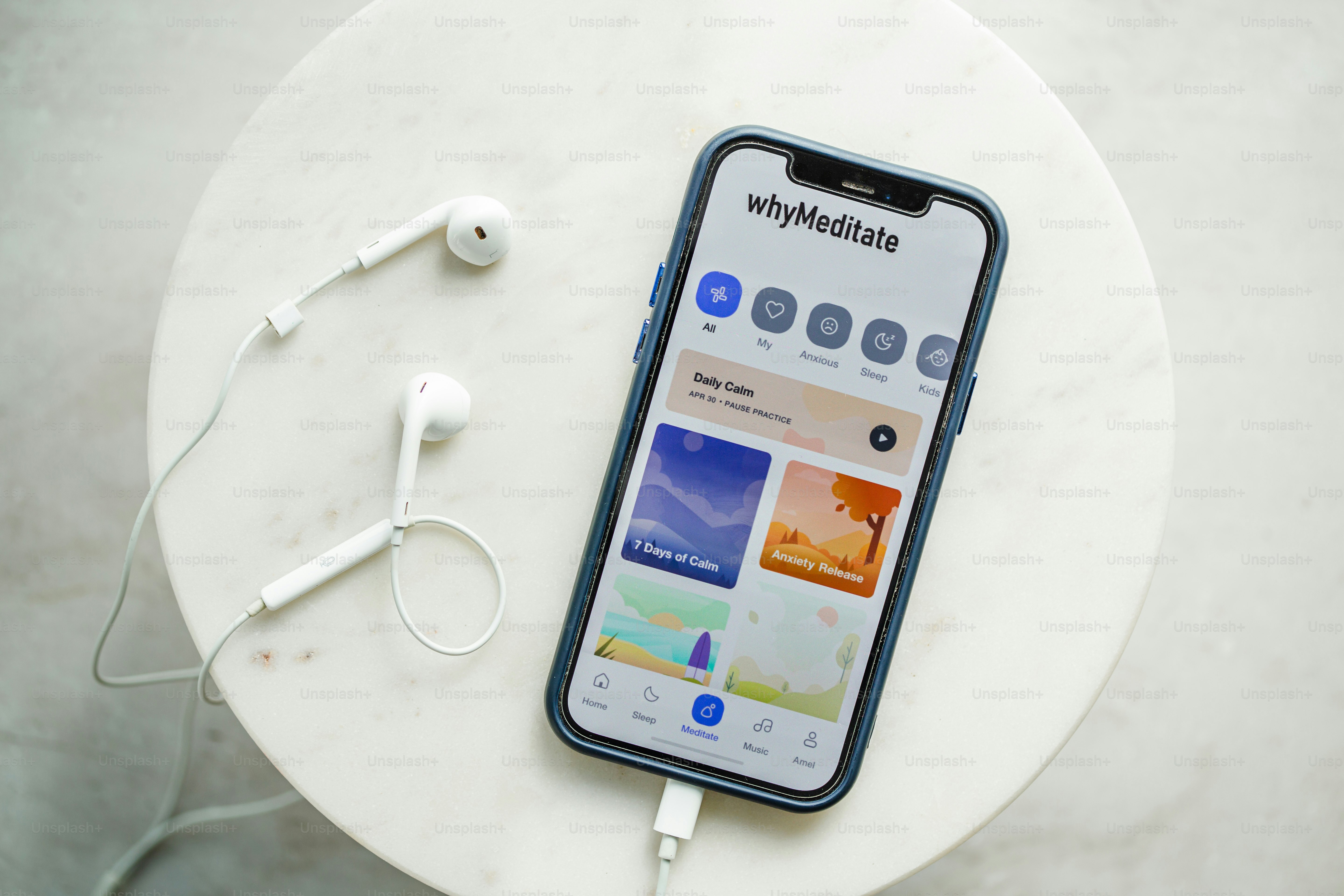 Un telefono con un'app per la meditazione accanto alle cuffie.
