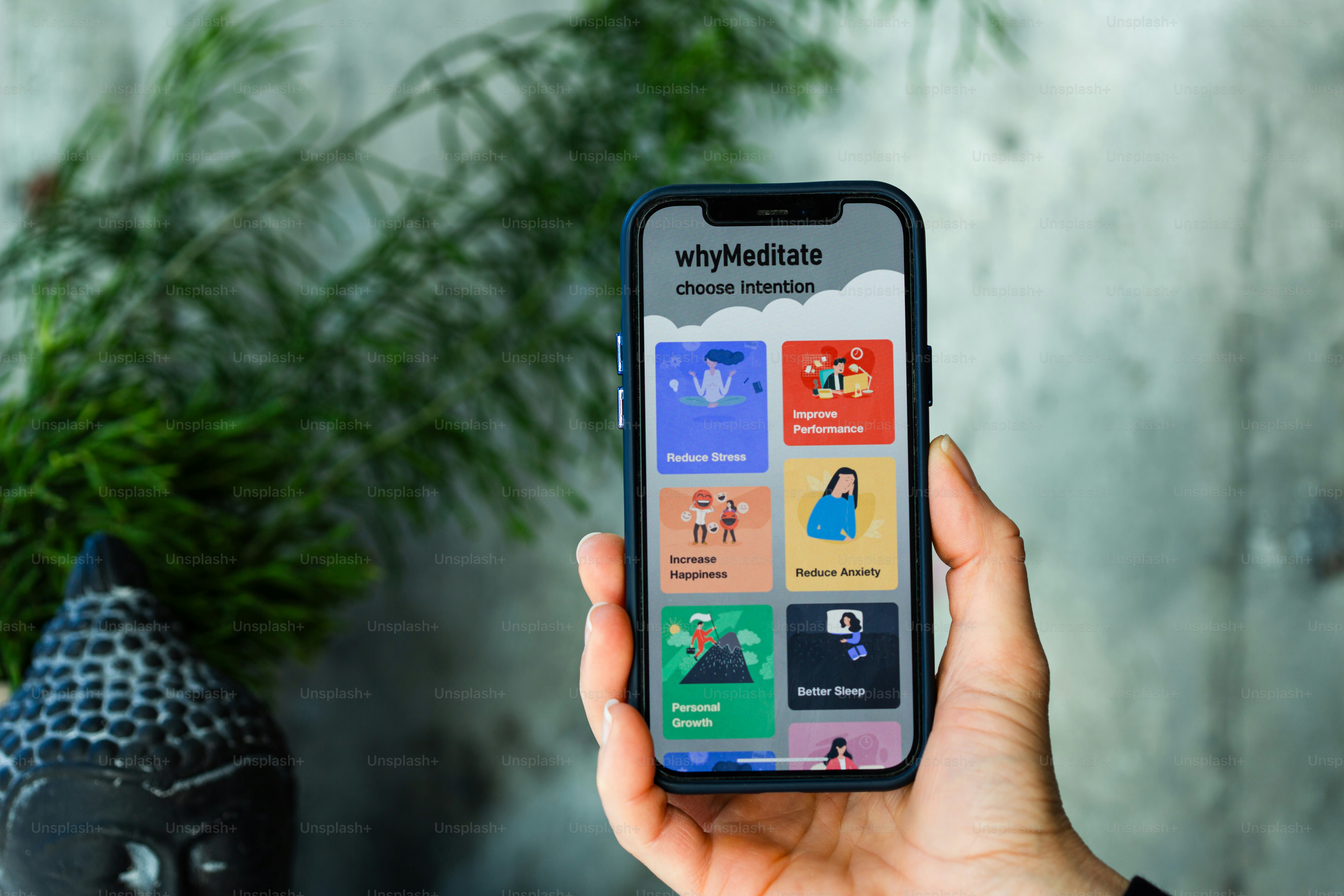 A hand holds a smartphone with a meditation app.