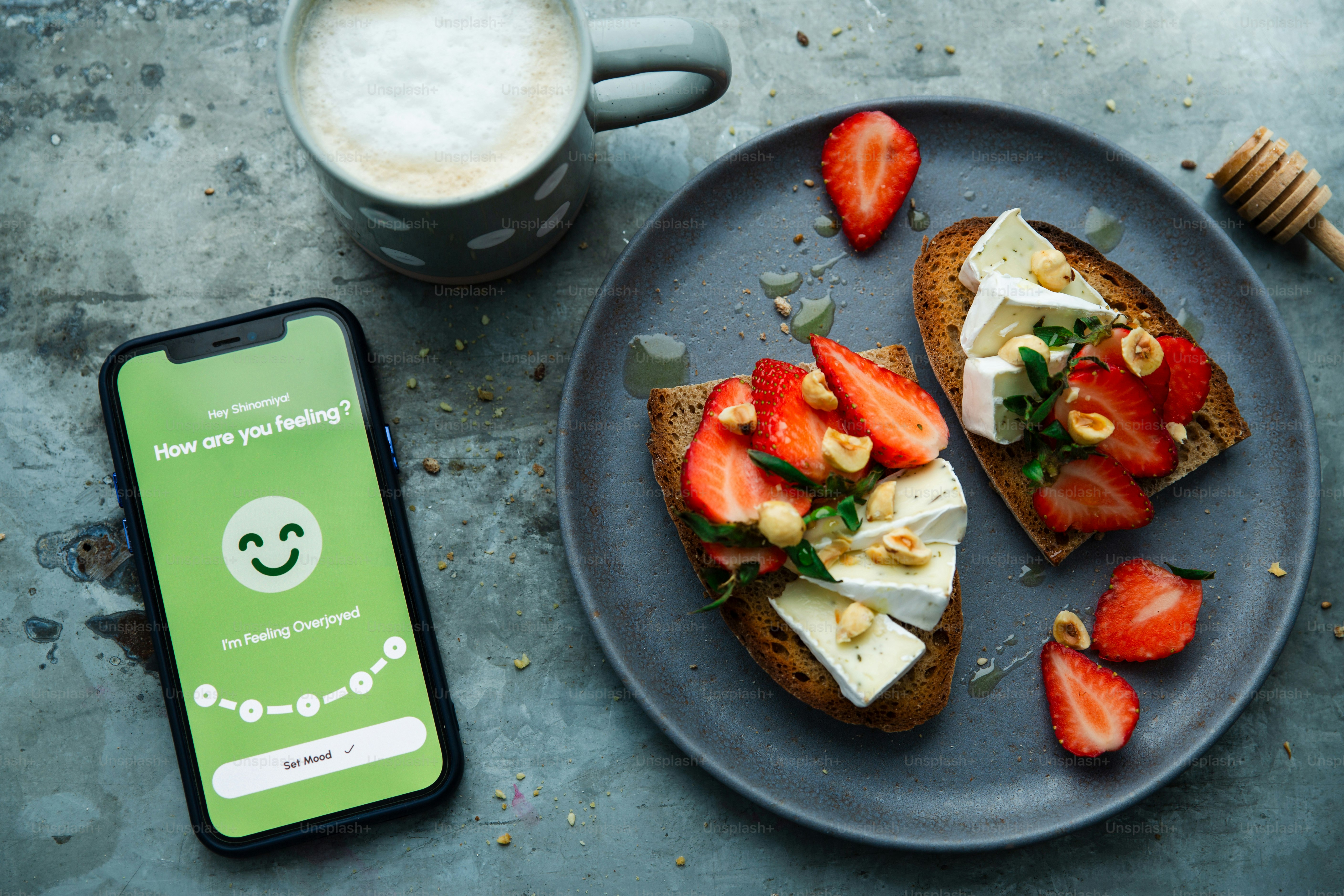 Breakfast with toast and strawberries alongside a phone.