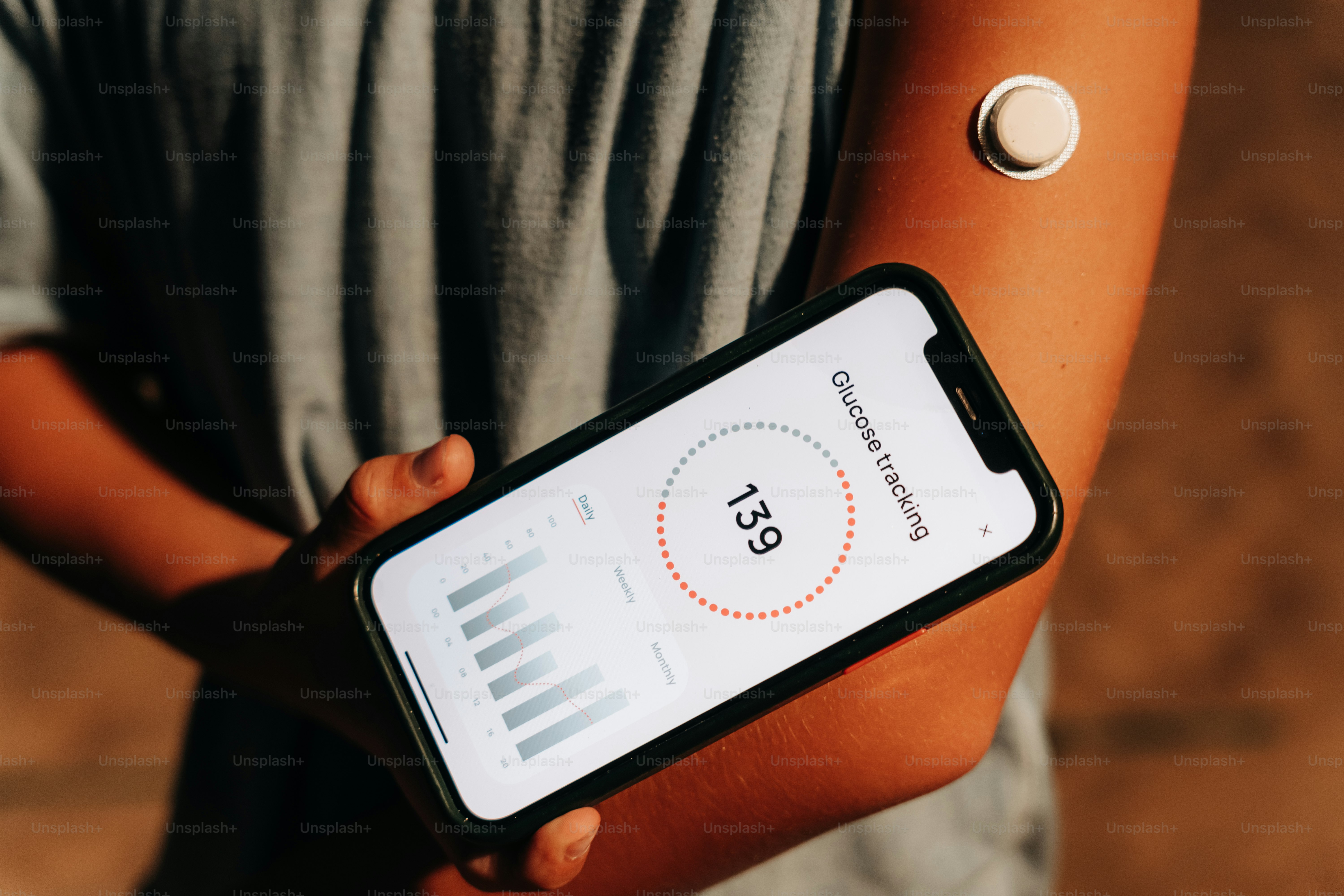 Person using a glucose monitor and smartphone.