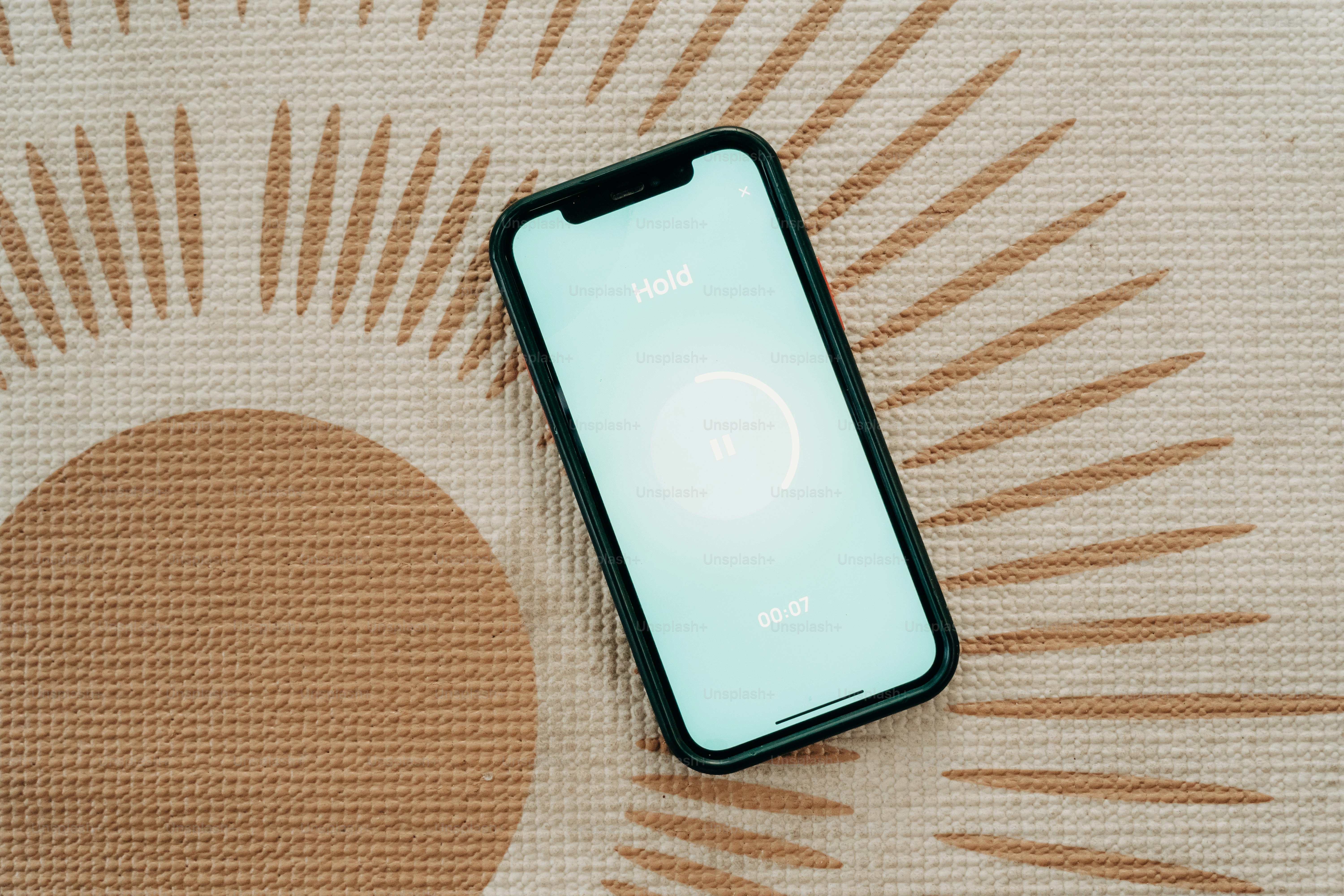 Telefon mit einer App, die auf einer gemusterten Matte ruht.