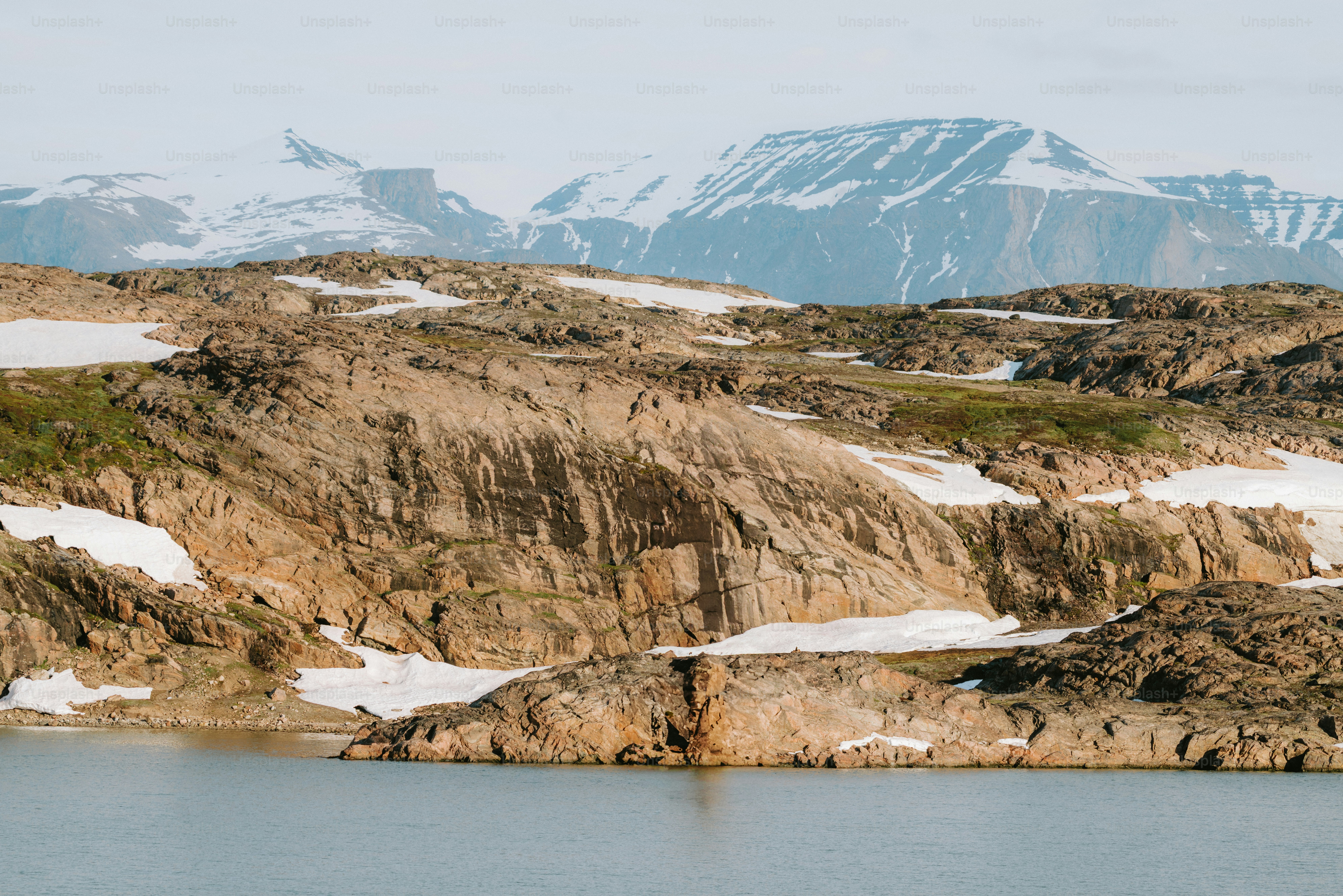Rocky landscape with snow-capped mountains in the background.