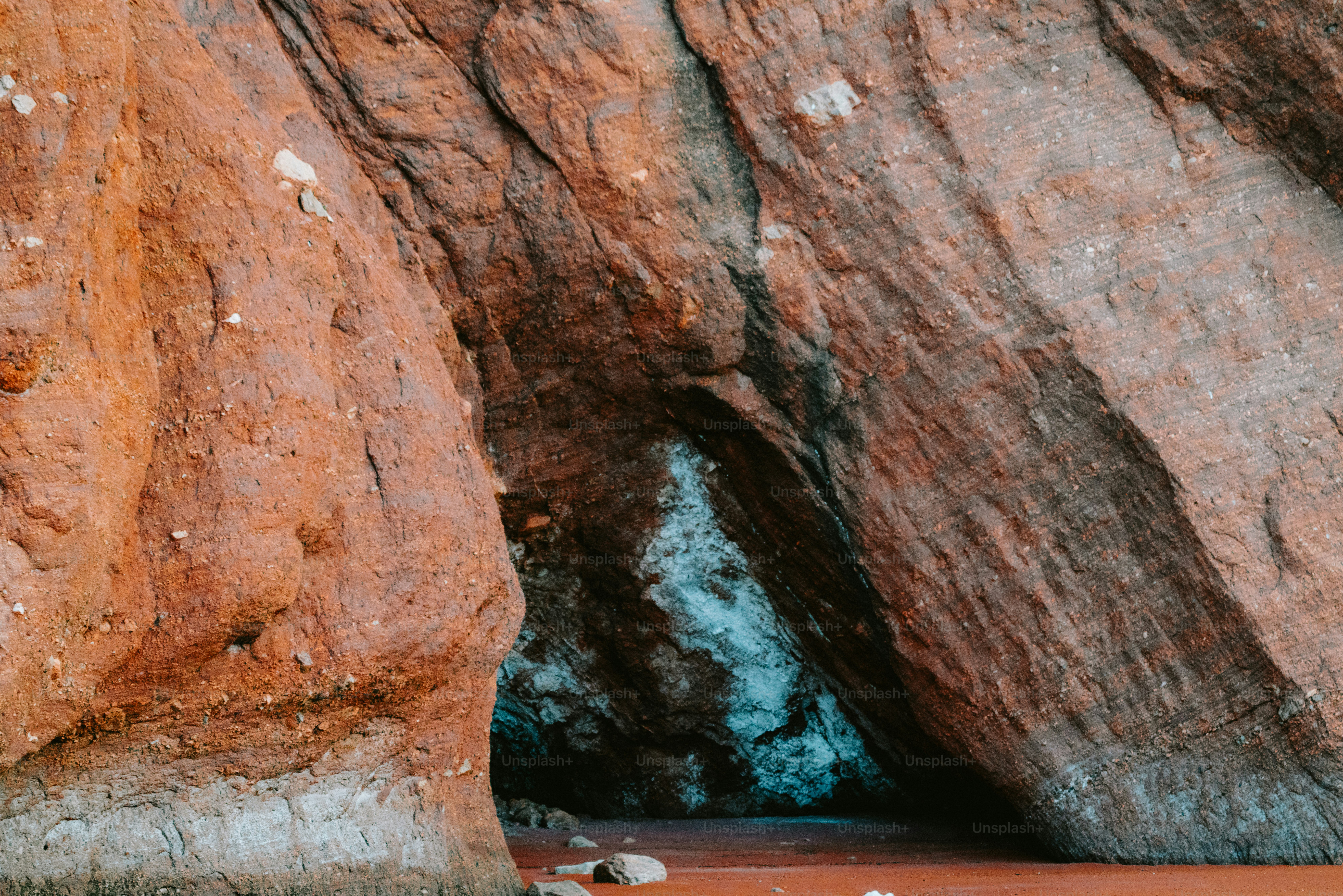 A cave entrance inside a rocky cliff. photo – Beach Image on Unsplash