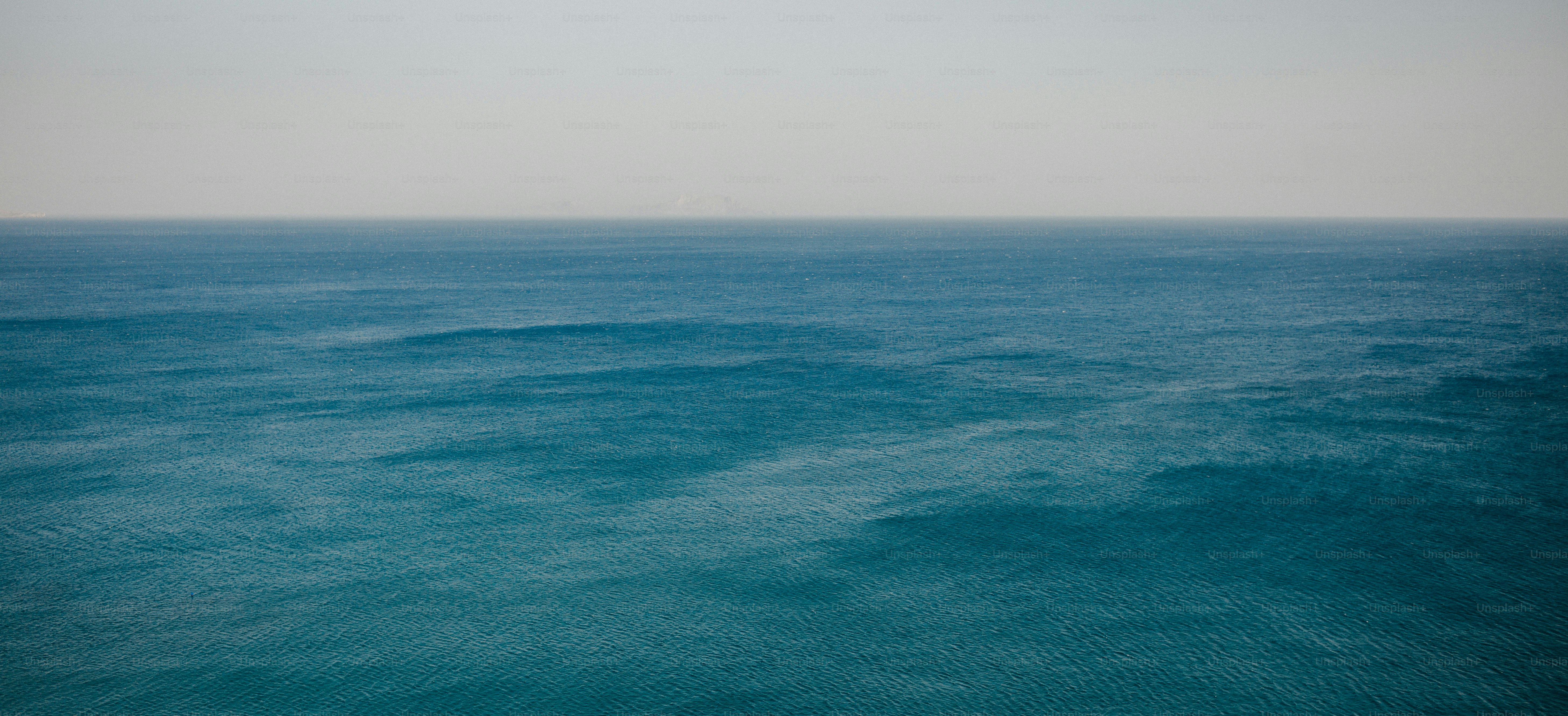 The ocean sprawls under a hazy sky.