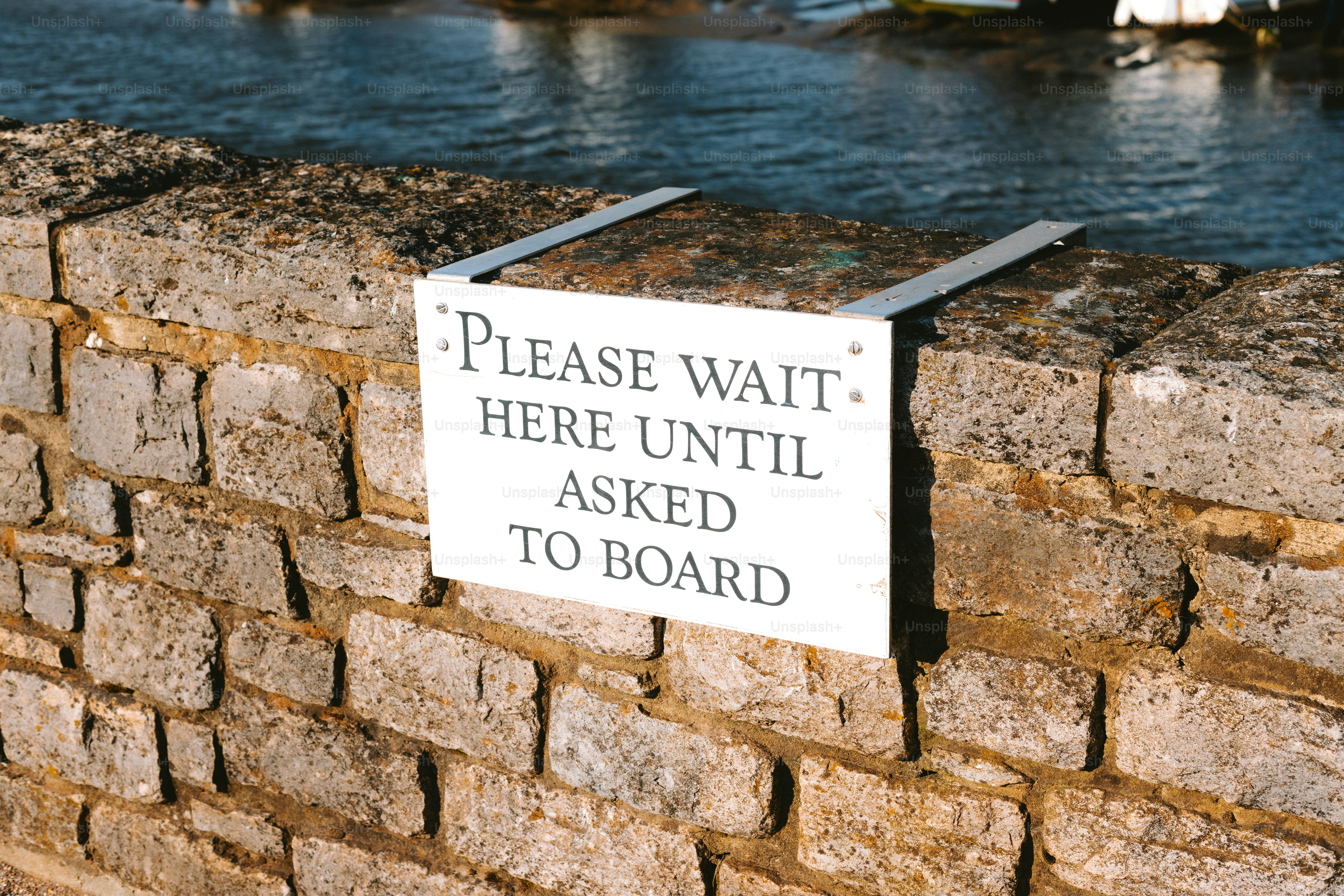 A sign asks people to wait until boarding.