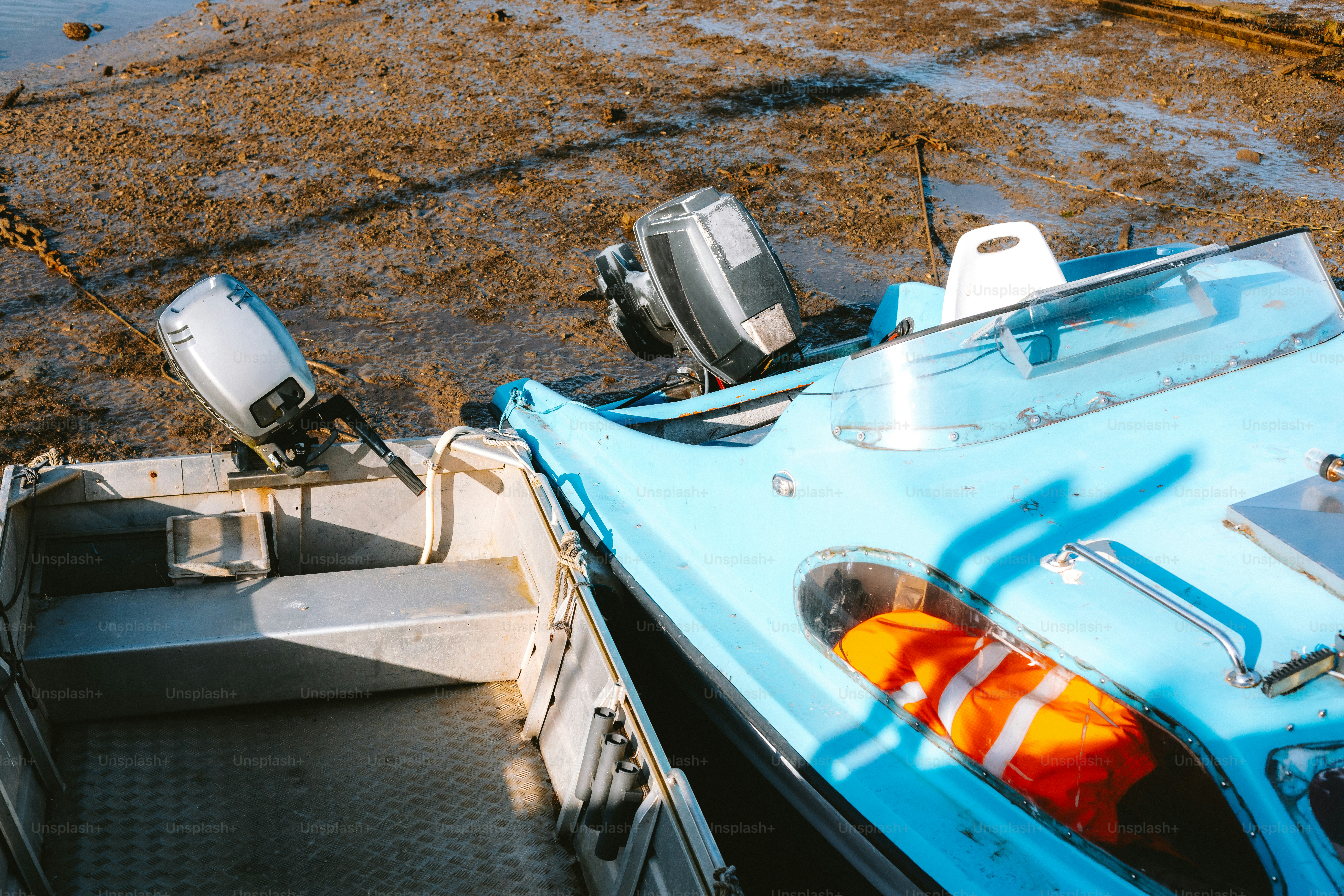 Boote liegen gestrandet an einer schlammigen Küste.