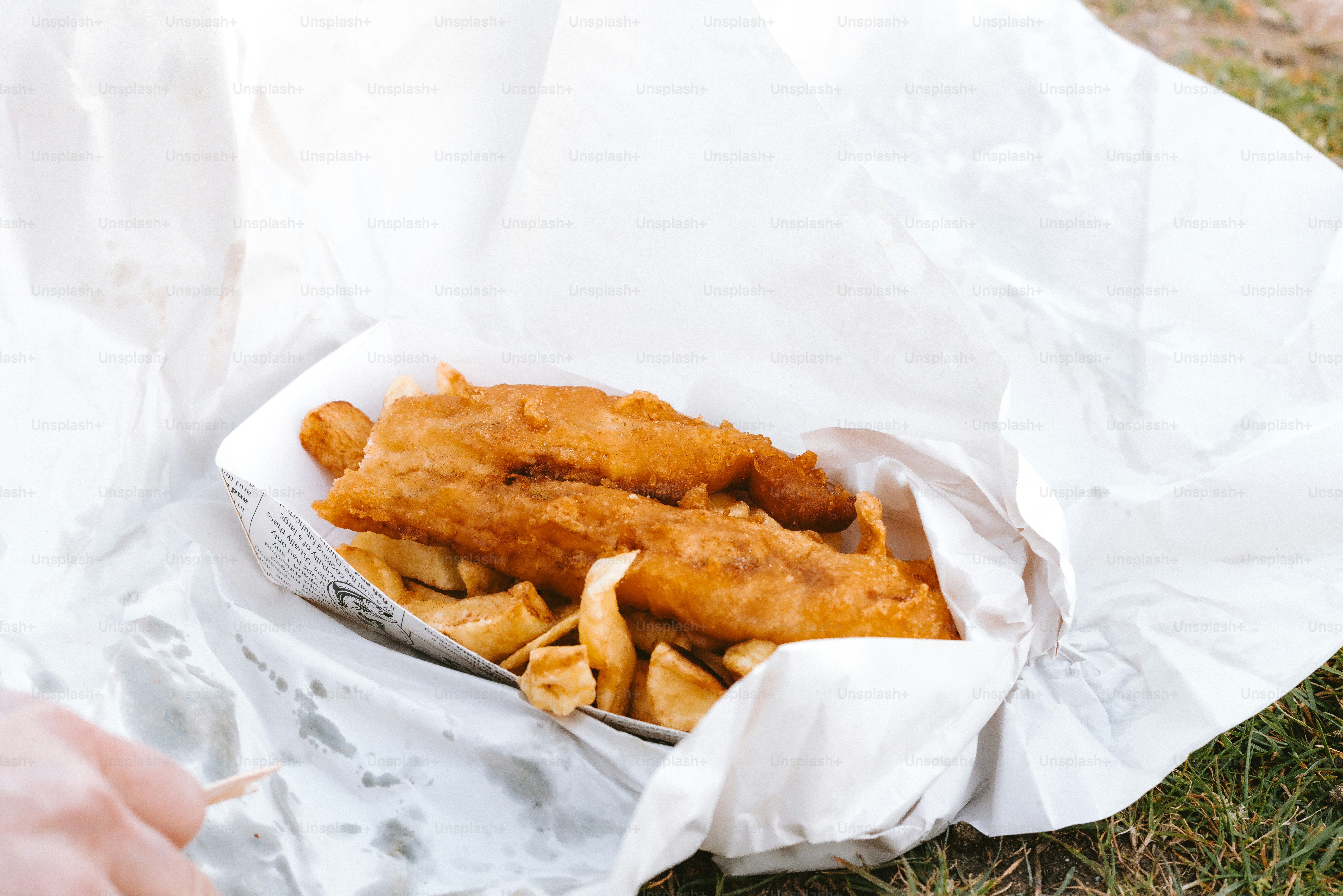 Fish and chips served in a paper container.