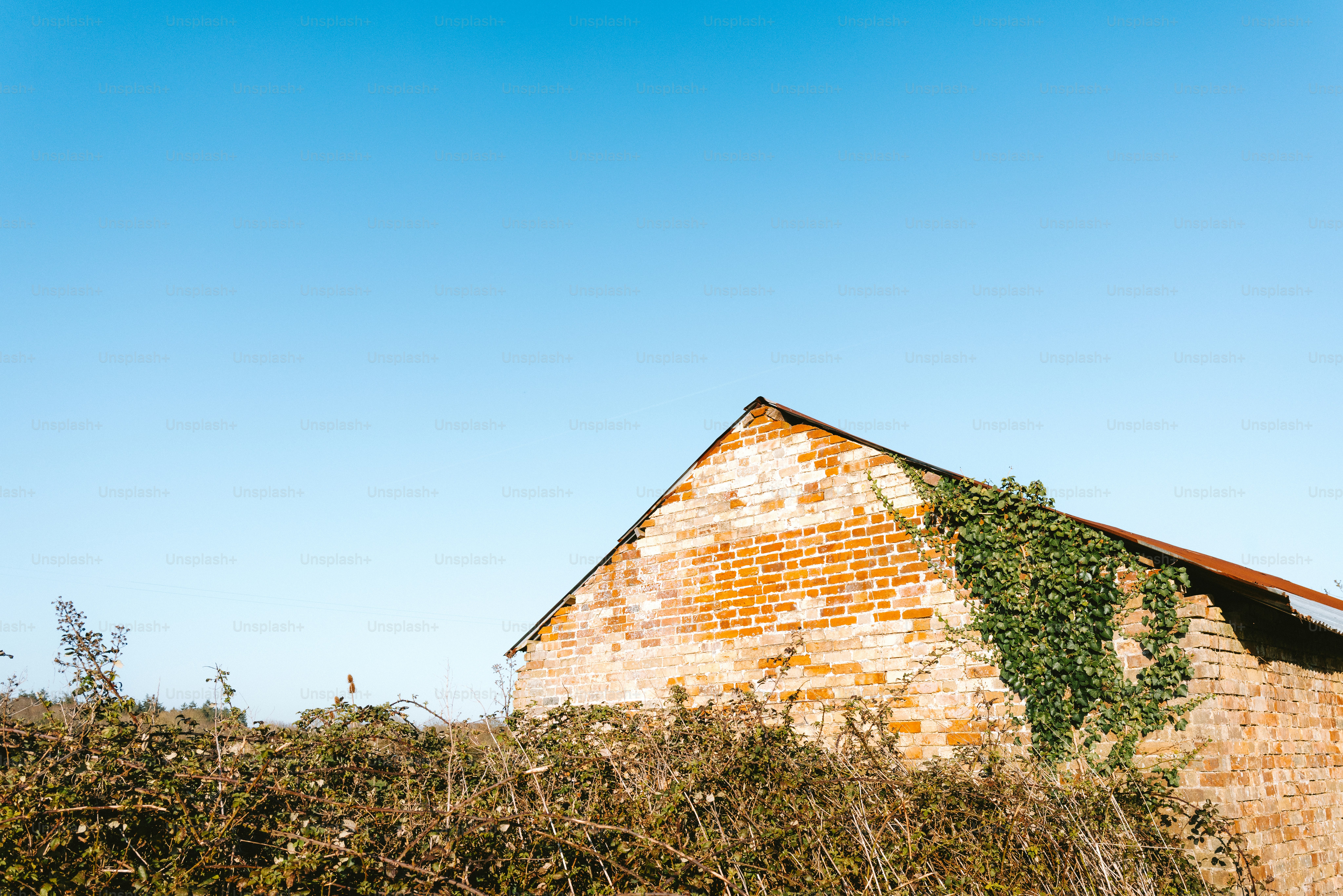 An old brick building sits beneath a bright blue sky.